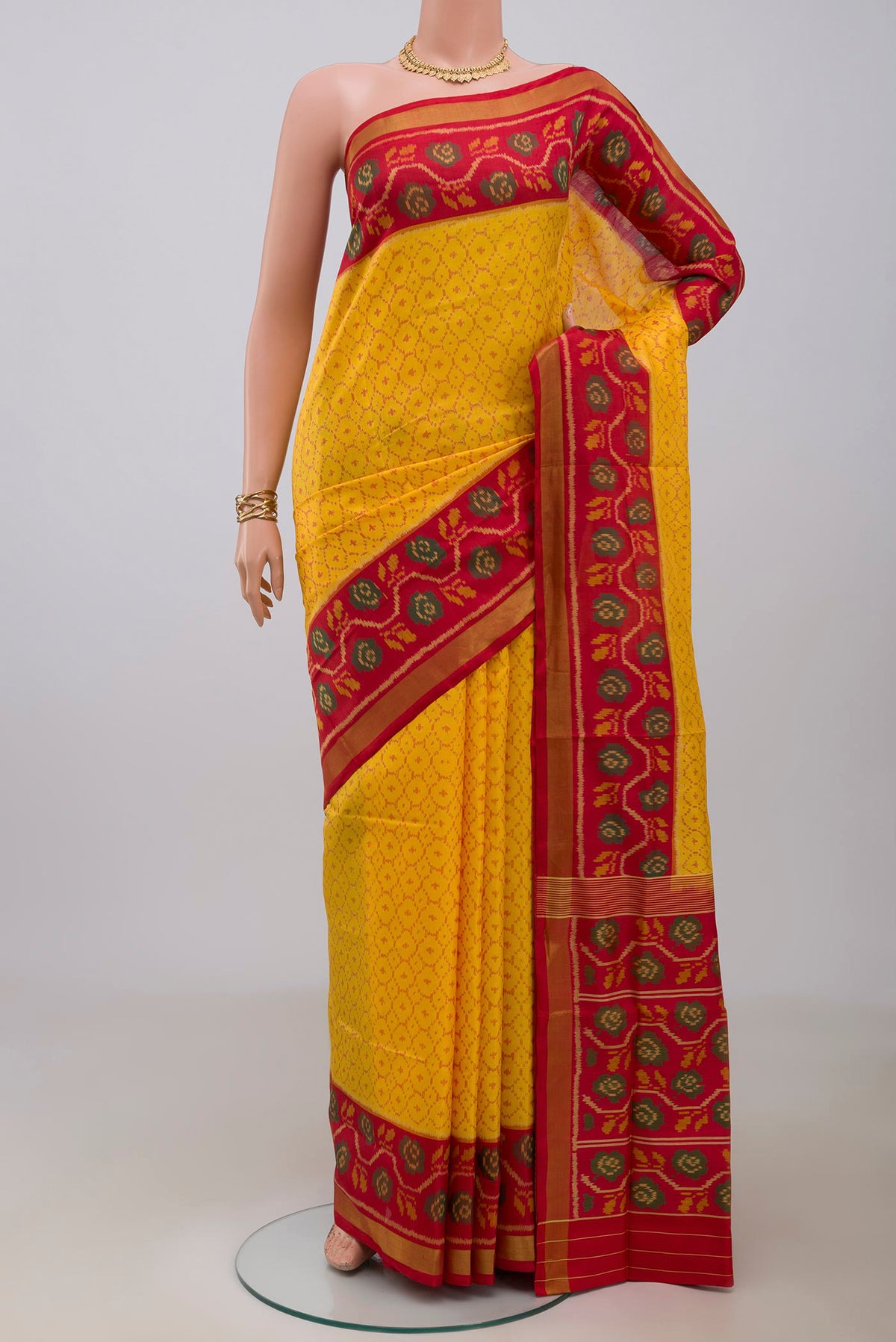 Yellow Rajkot Patola Silk Saree with Ikat design on the body and Ikat Border.  displayed on a mannequin