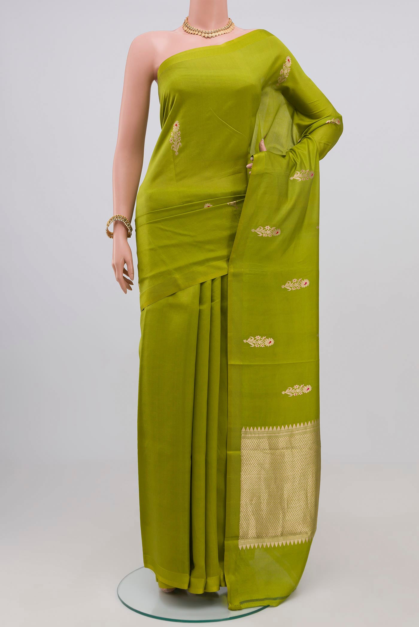 Parrot Green Banarasi Katan Silk Saree with Zari Butta on the body and Zari Border.  displayed on a mannequin