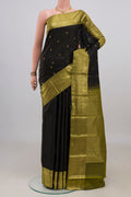 Pure Silk Black Kanchipuram Saree with Zari Butta on the body and Zari Border.  displayed on a mannequin