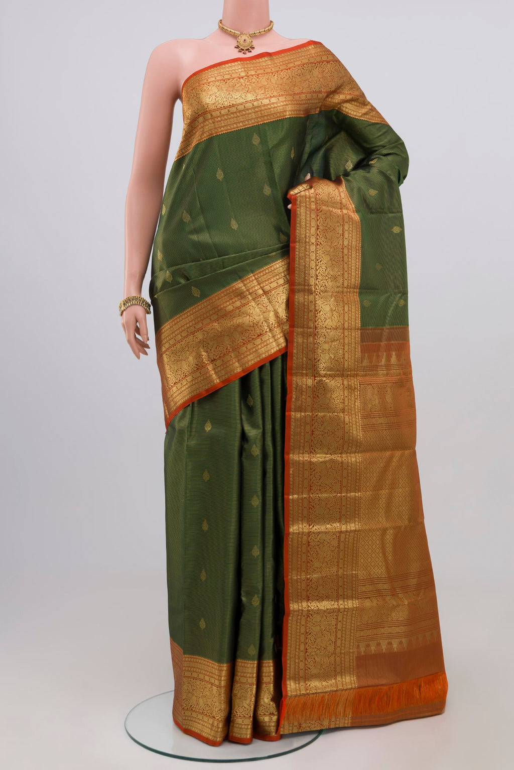 Green Kanjivaram Silk Saree with Zari Butta on the body and Zari Border.  displayed on a mannequin