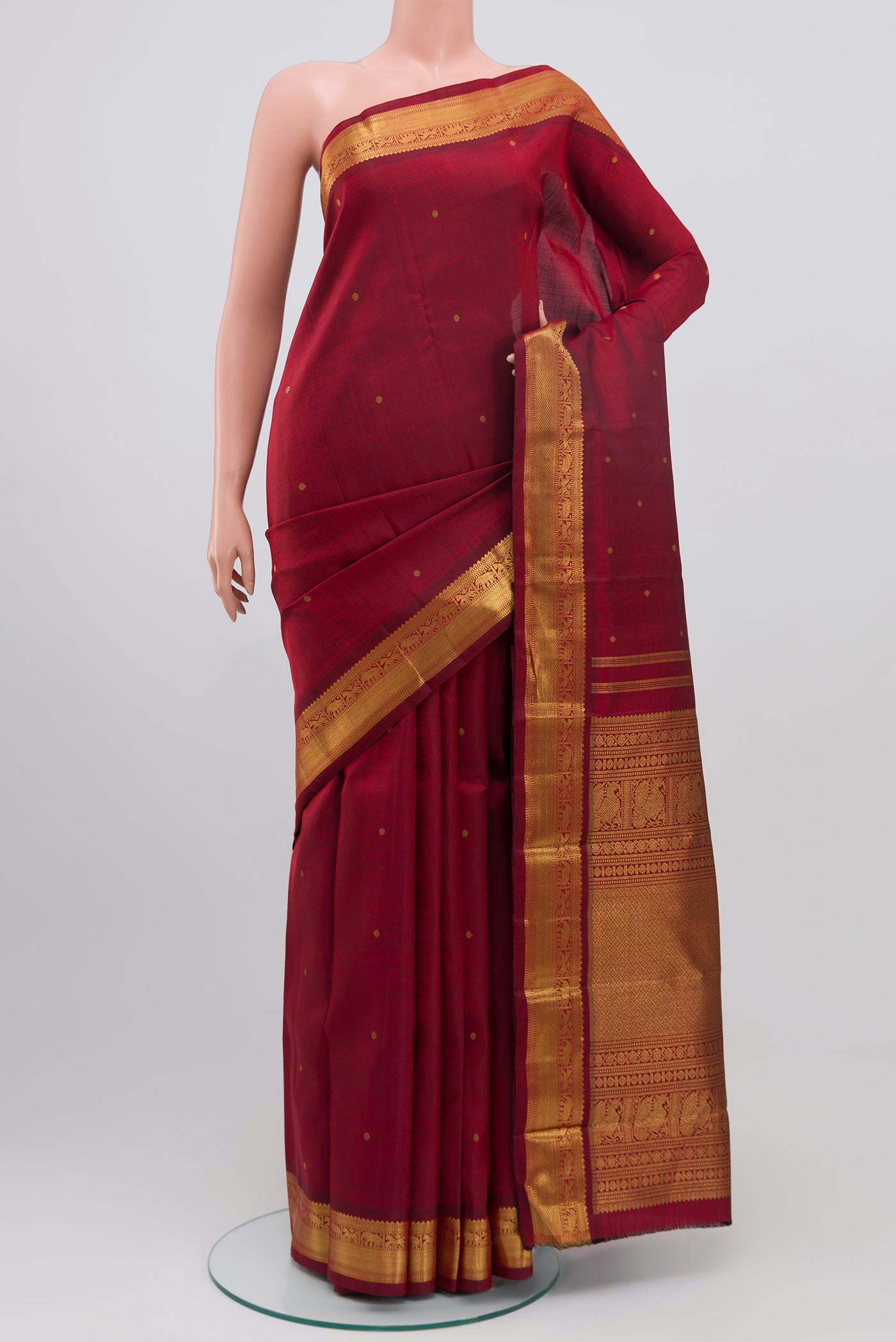 Pure Silk Pure Zari Maroon Kanchipuram Saree with Zari Butta on the body and Zari Border.  displayed on a mannequin