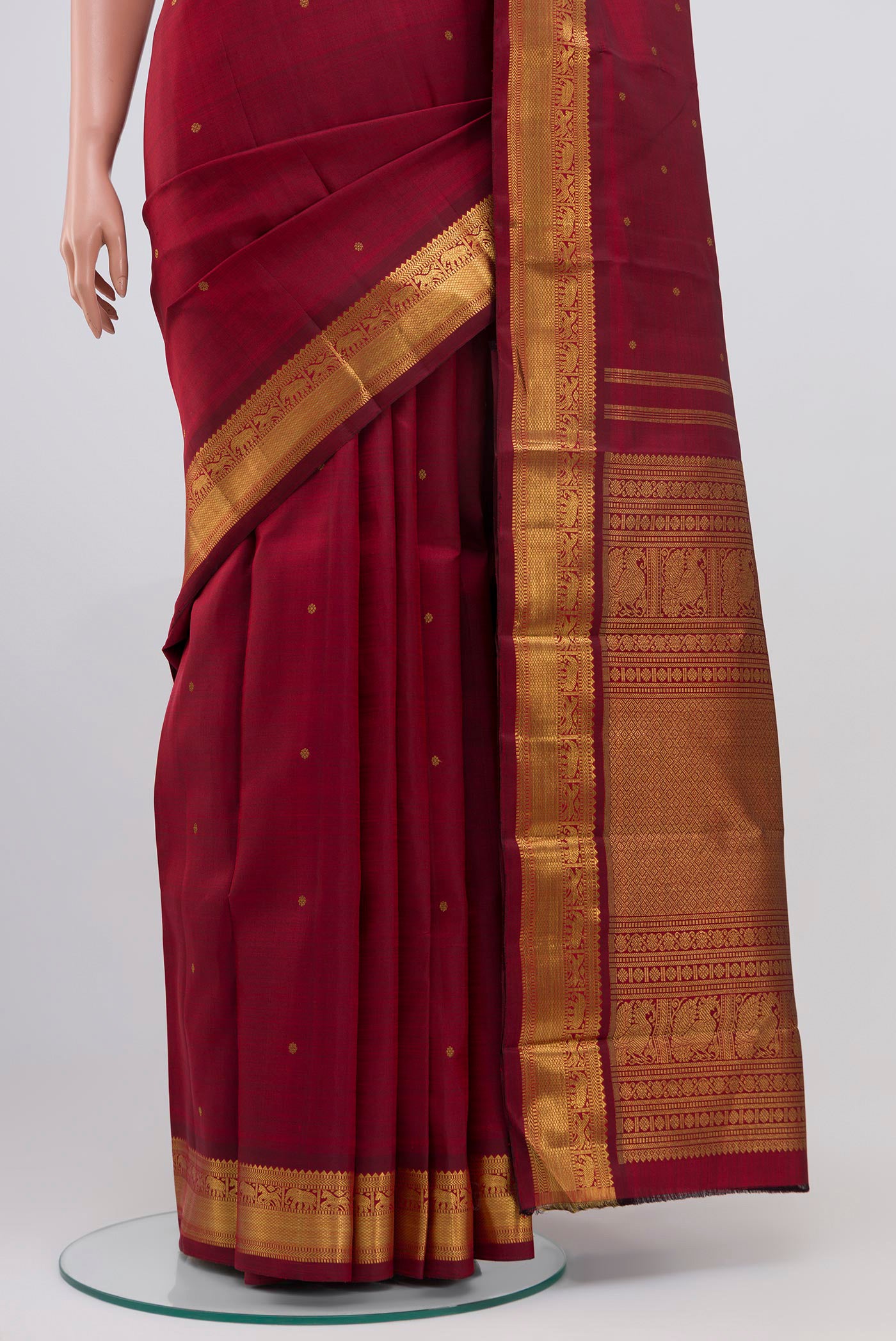 Pleats and pallu of Pure Silk Pure Zari Maroon Kanchipuram Saree with Zari Butta on the body and Zari Border. 