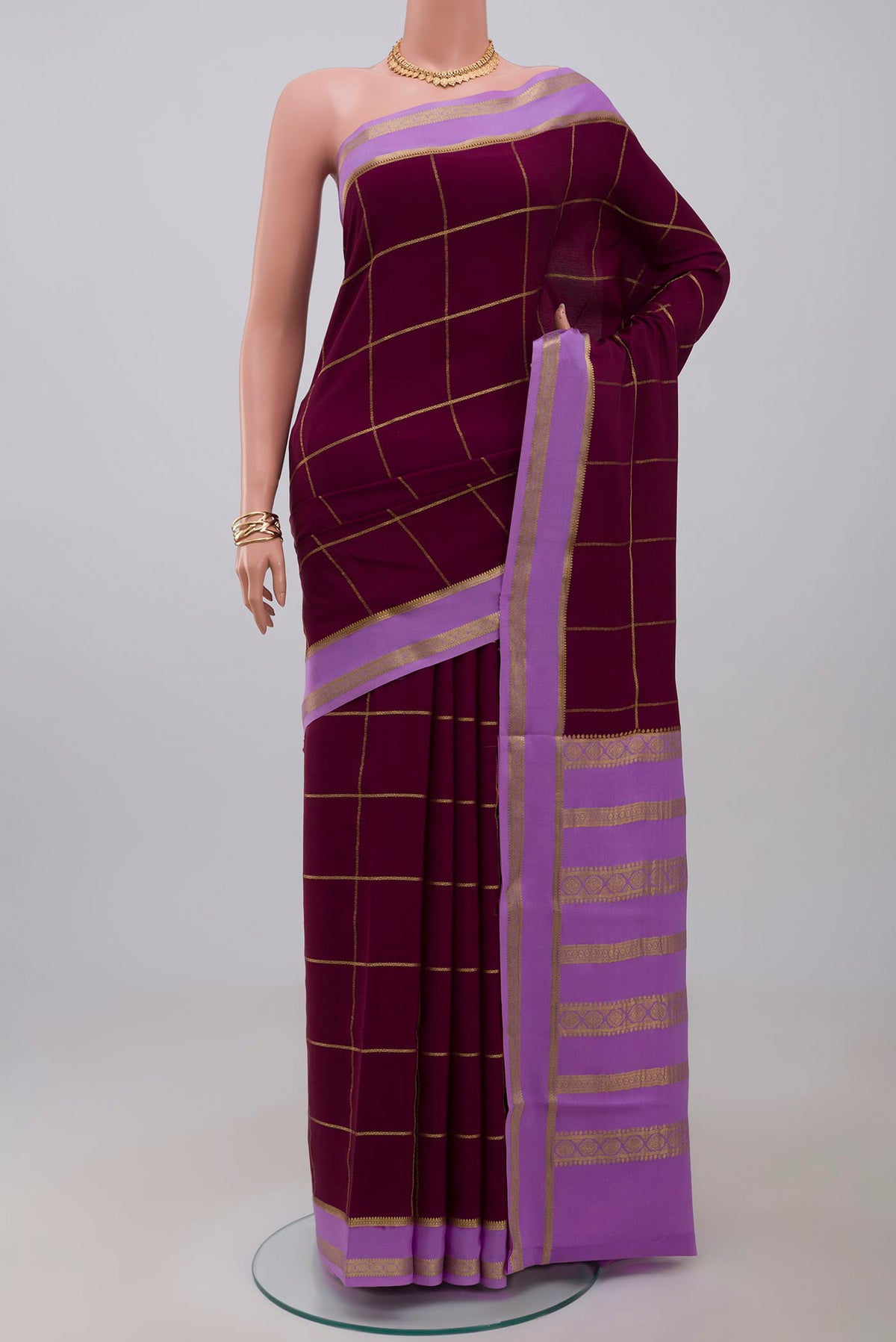 Purple Crepe Saree with Checked design on the body and Thin Zari Line.  displayed on a mannequin