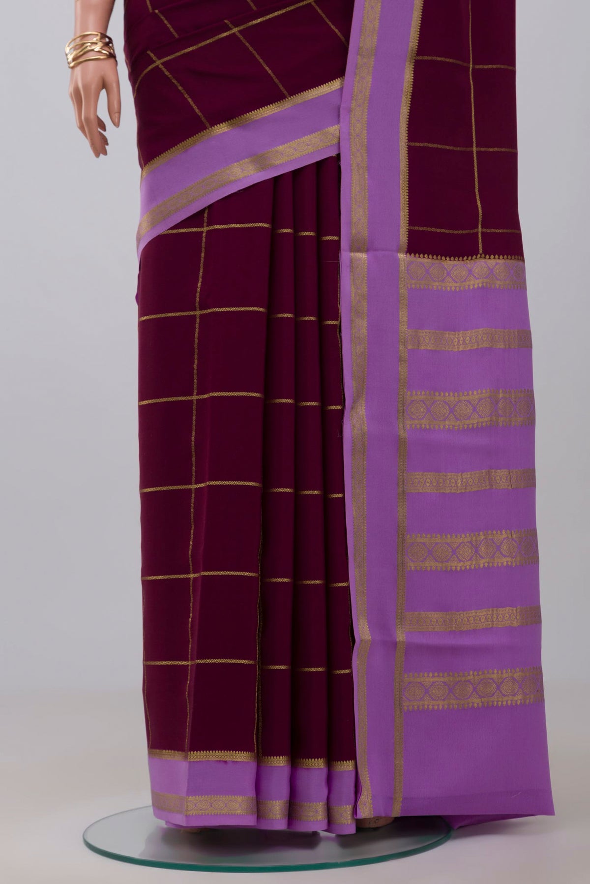 Pleats and pallu of Purple Crepe Saree with Checked design on the body and Thin Zari Line. 