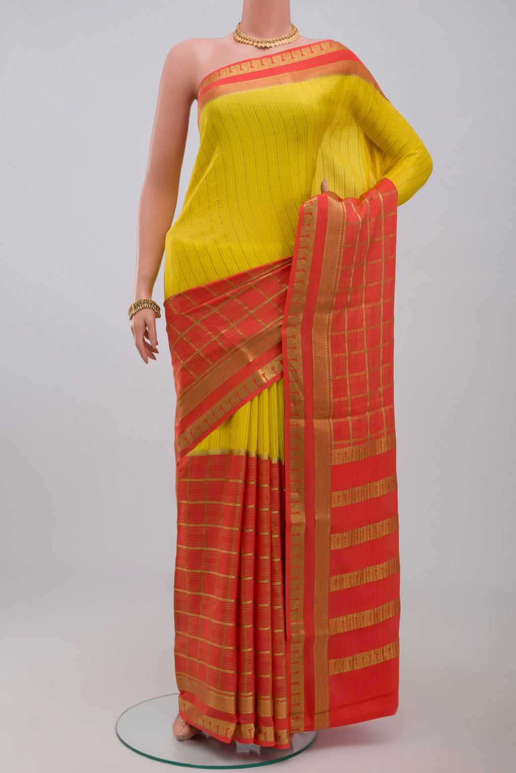 Yellow Crepe Saree with Fancy on the body and Zari Border.  displayed on a mannequin