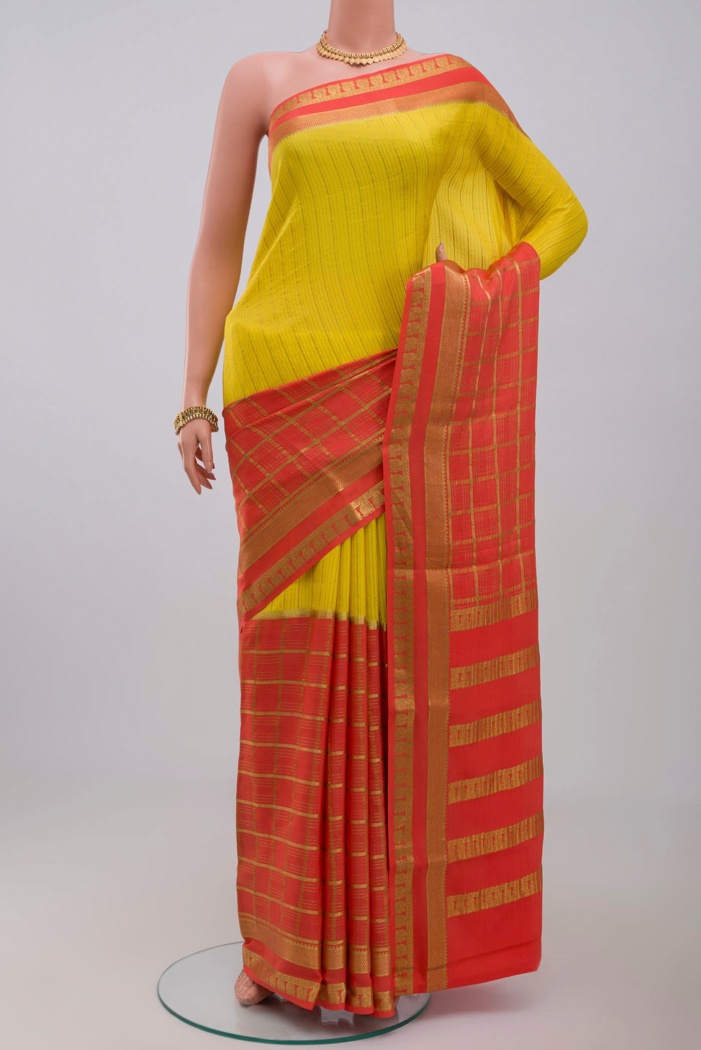 Yellow Crepe Saree with Fancy on the body and Zari Border.  displayed on a mannequin