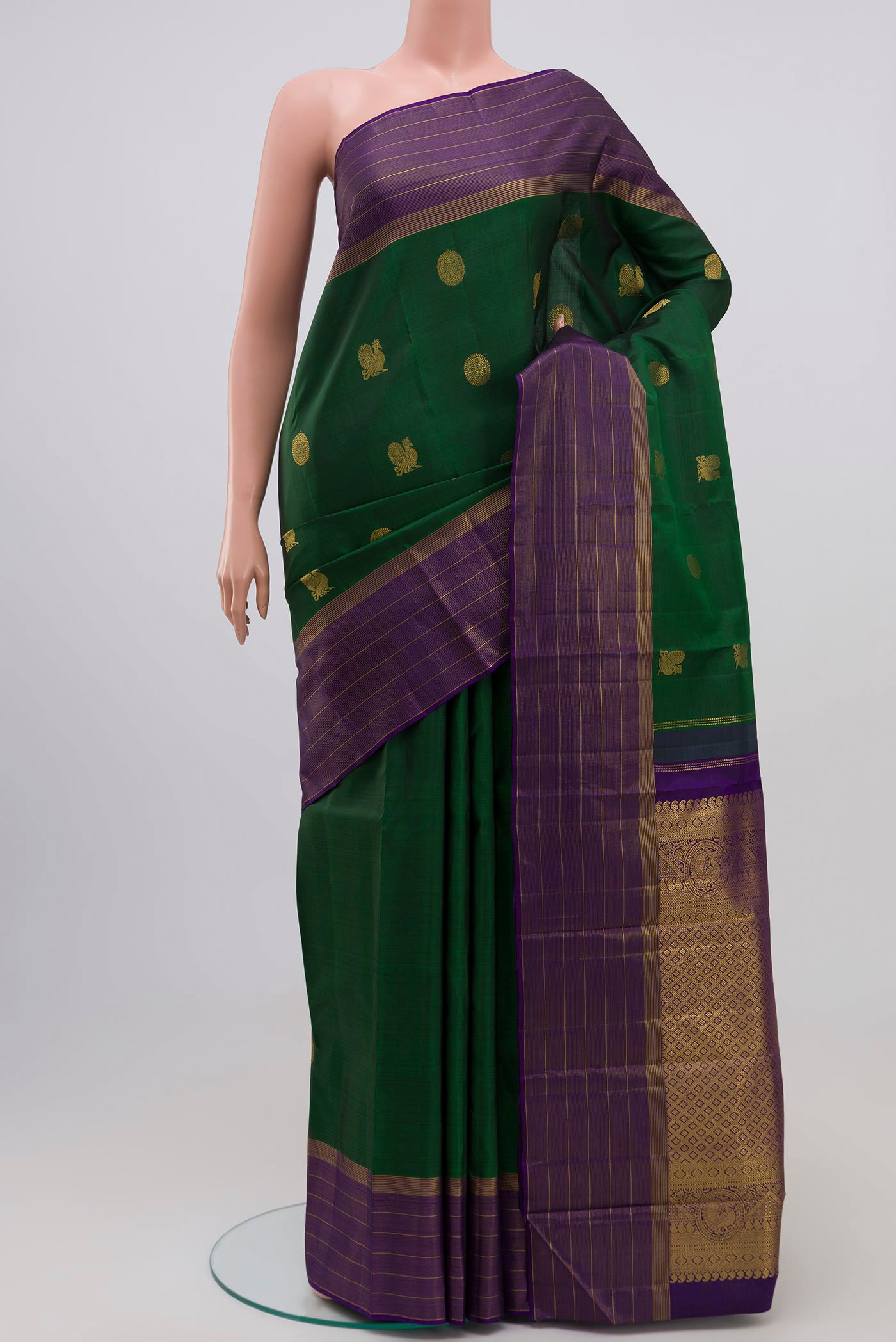 Bottle Green Kanjivaram Silk Saree with Zari Butta on the body and Zari Border.  displayed on a mannequin