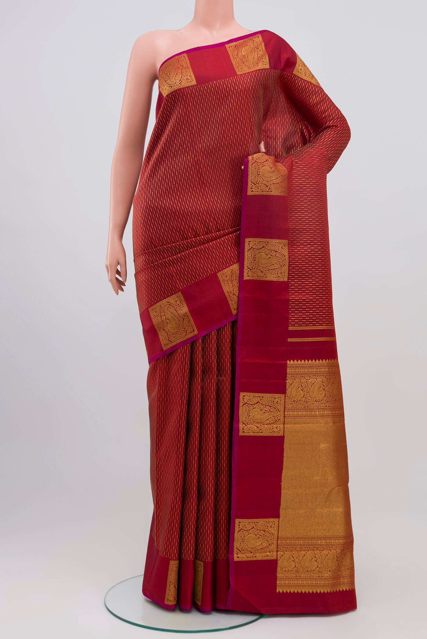 Maroon Kanjivaram Saree with Stripes on the body and Fancy Border.  displayed on a mannequin