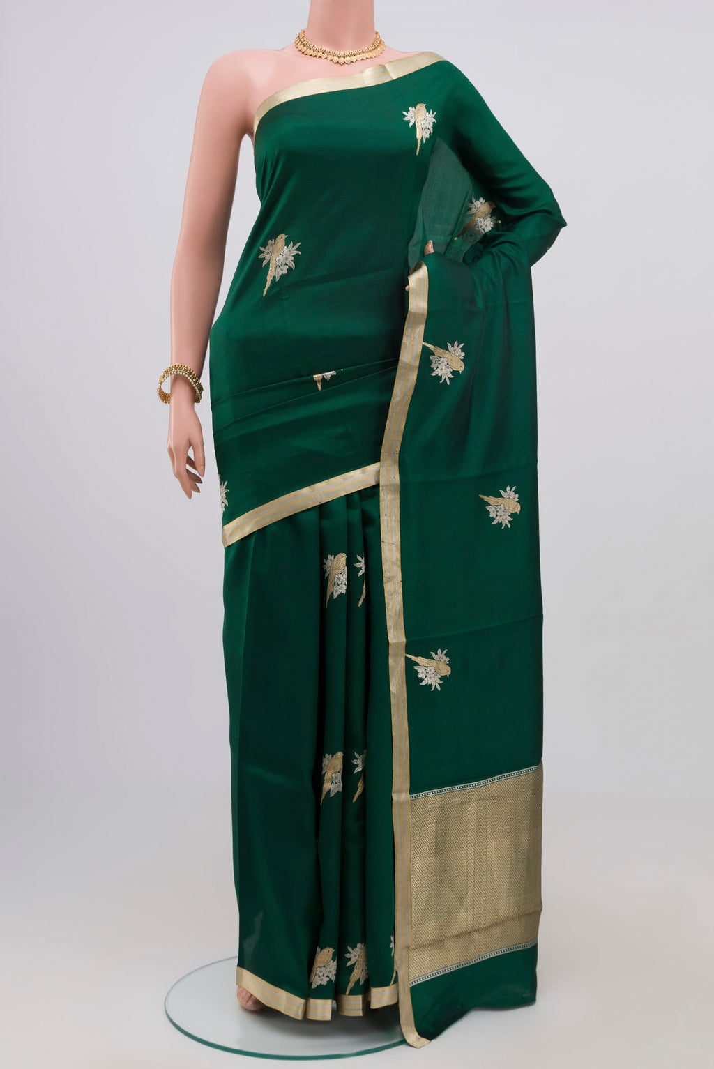Bottle Green Banarasi Katan Silk Saree with Zari Butta on the body and Zari Border.  displayed on a mannequin