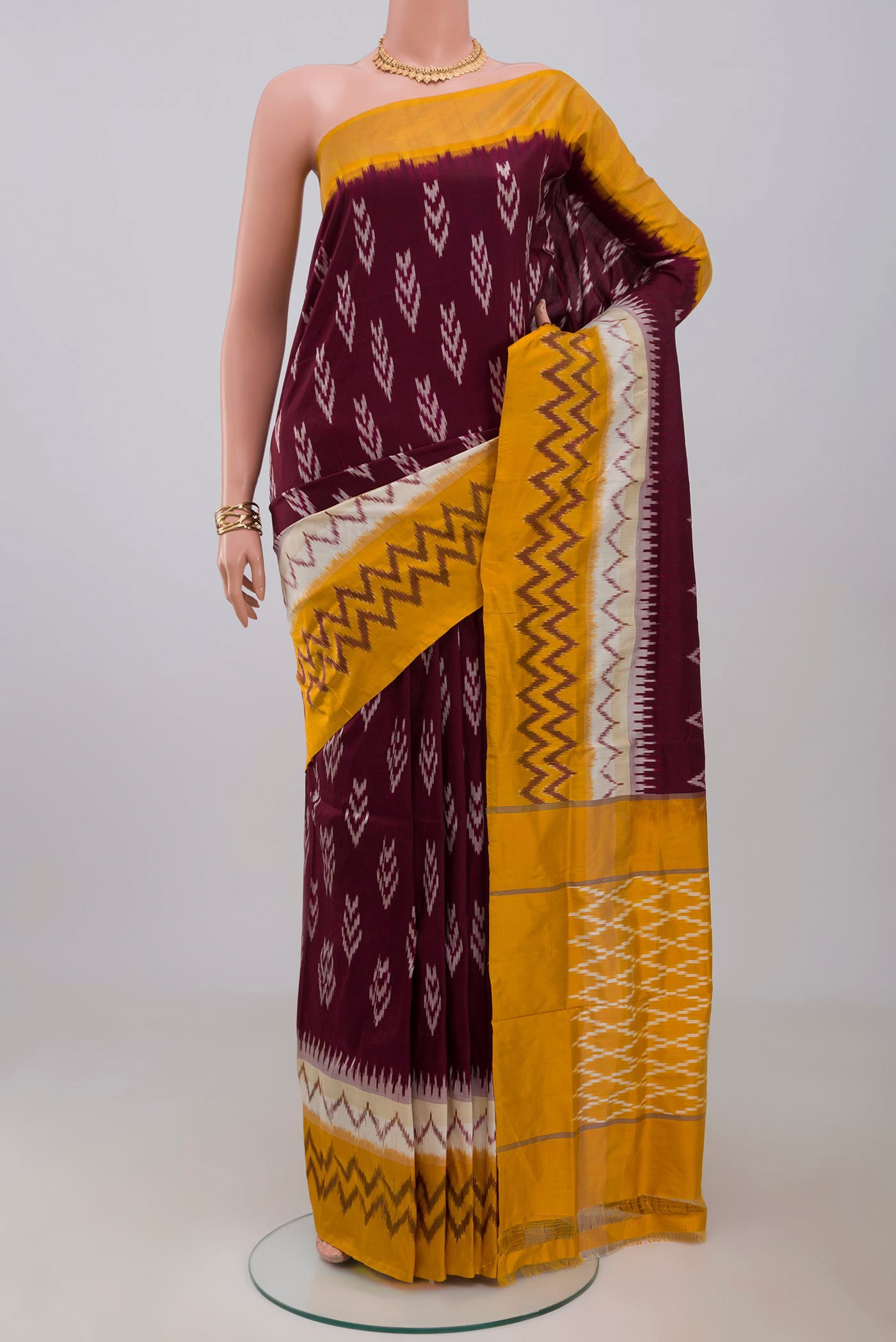 Brown Pochampally Saree with Ikat Print on the body and Ikat Border.  displayed on a mannequin