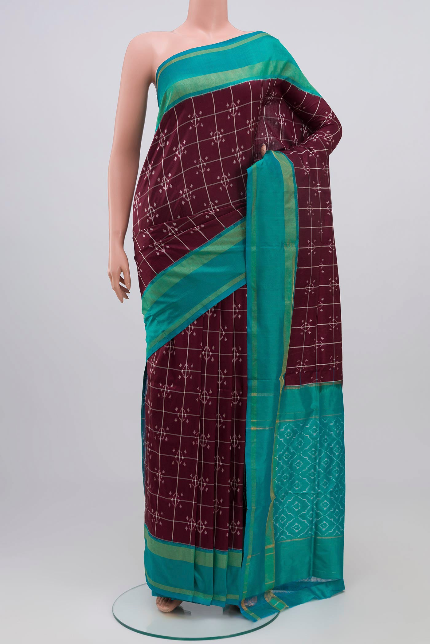 Brown Pochampally Silk Saree with Ikat Print on the body and Zari Border.  displayed on a mannequin
