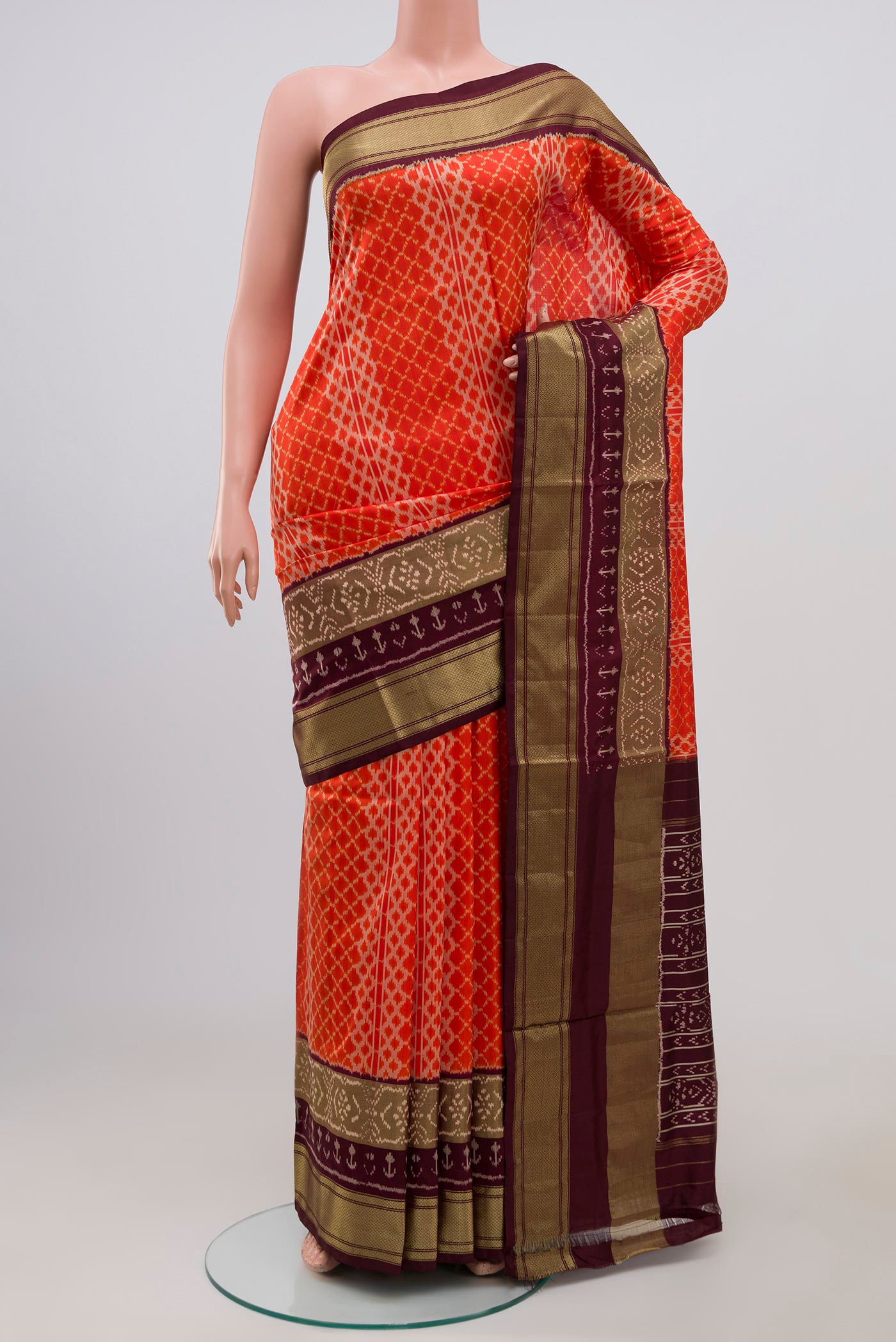 Orange Pochampally Silk Saree with Ikat Print on the body and Zari Border.  displayed on a mannequin