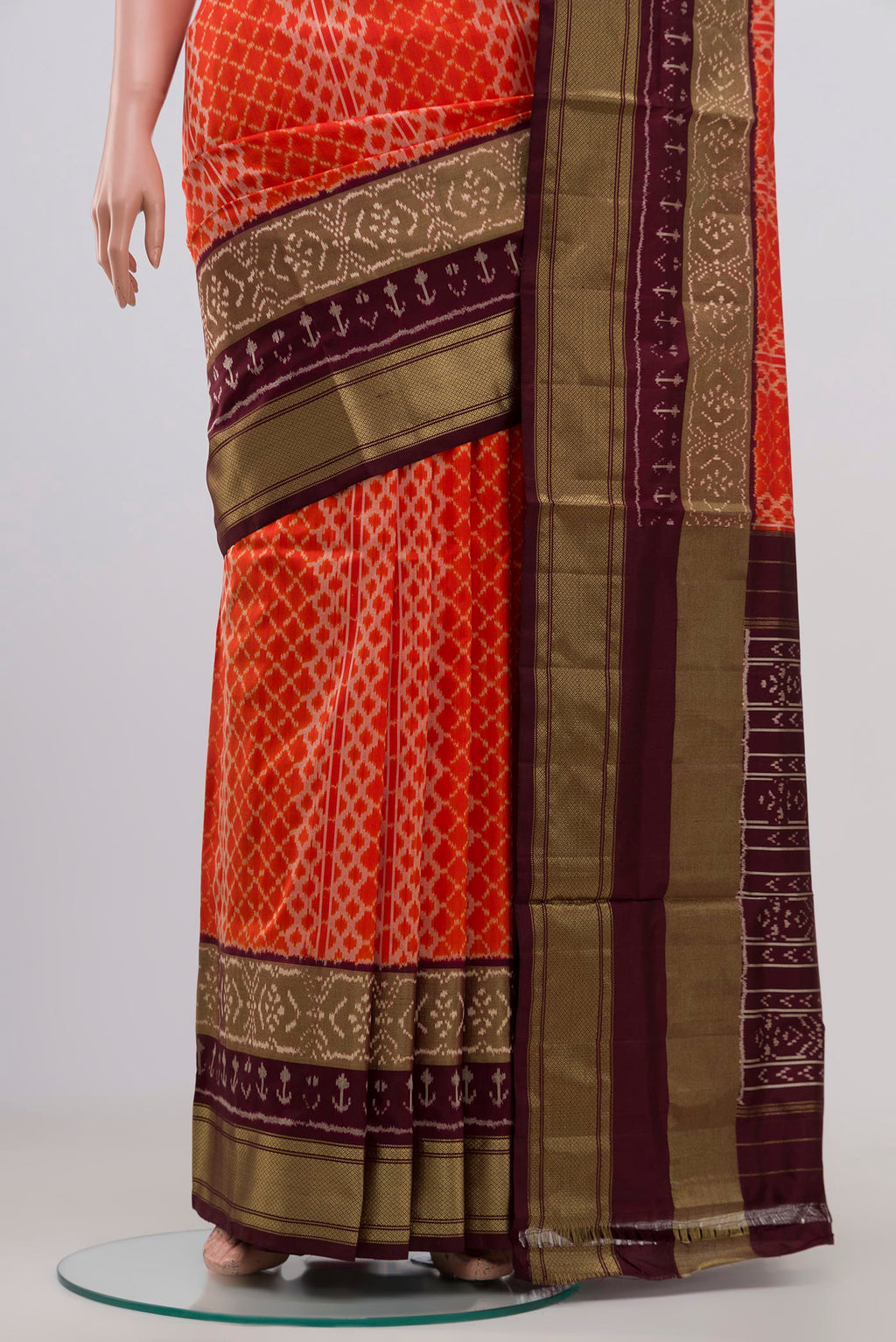 Pleats and pallu of Orange Pochampally Silk Saree with Ikat Print on the body and Zari Border. 