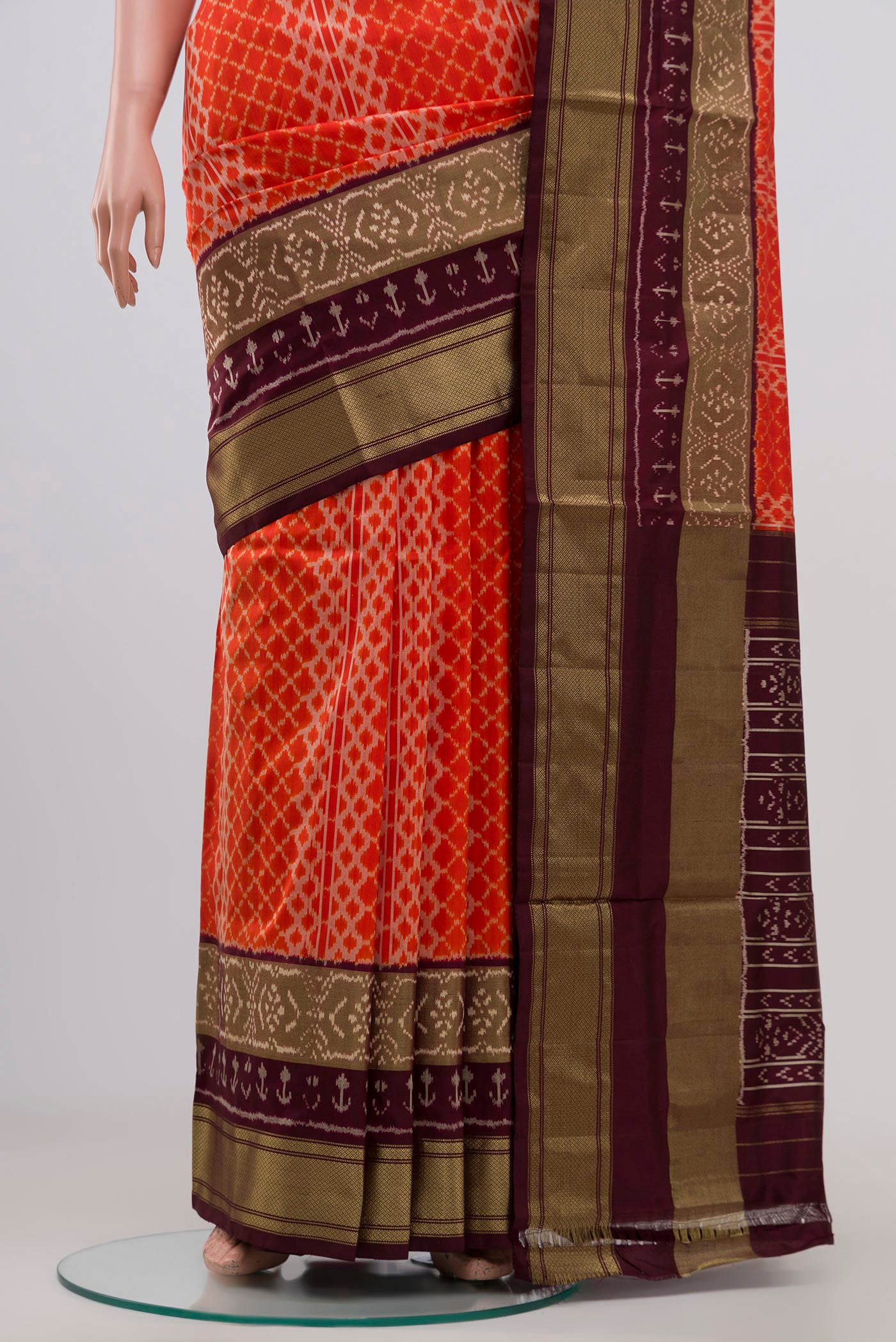 Pleats and pallu of Orange Pochampally Silk Saree with Ikat Print on the body and Zari Border. 
