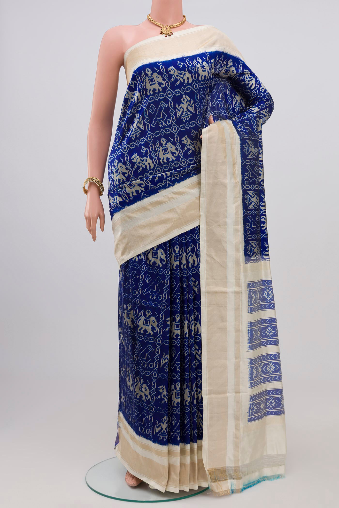 Navy Blue Pochampally Silk Saree with Ikat Print on the body and Zari Border.  displayed on a mannequin