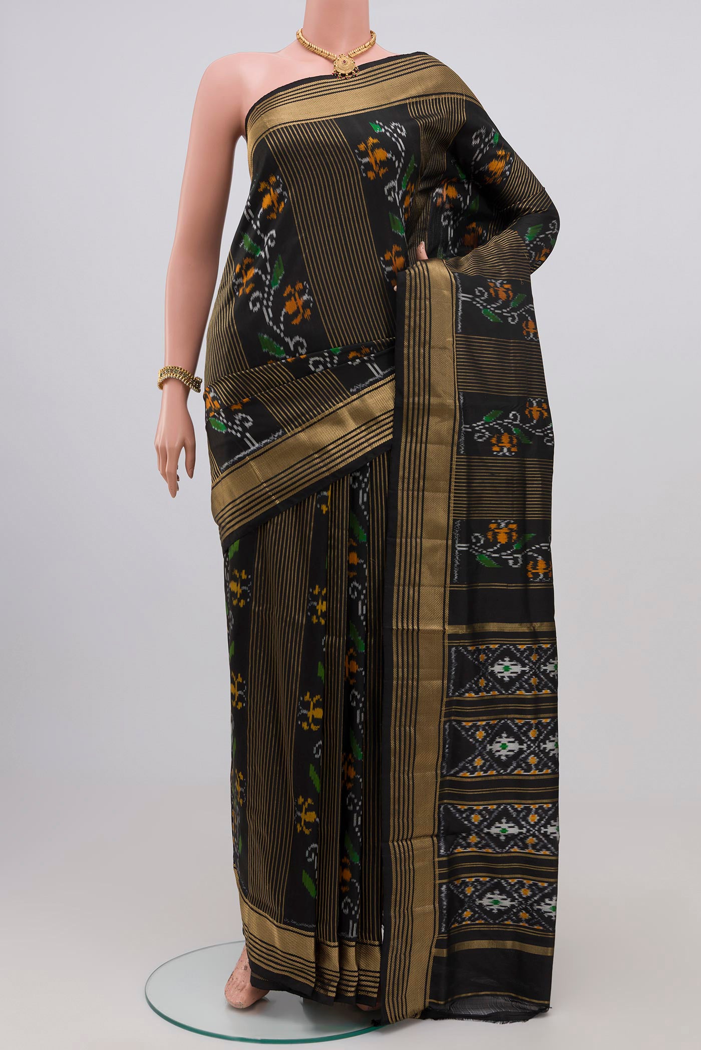 Black Pochampally Silk Saree with Ikat Print on the body and Zari Border.  displayed on a mannequin