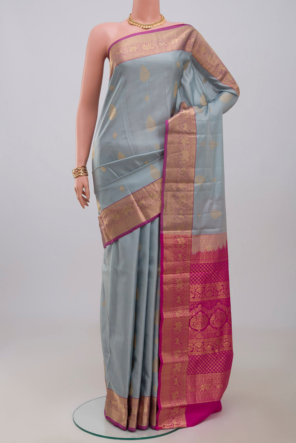 Grey Kanjivaram Silk Saree with Zari Butta on the body and Zari Border.  displayed on a mannequin