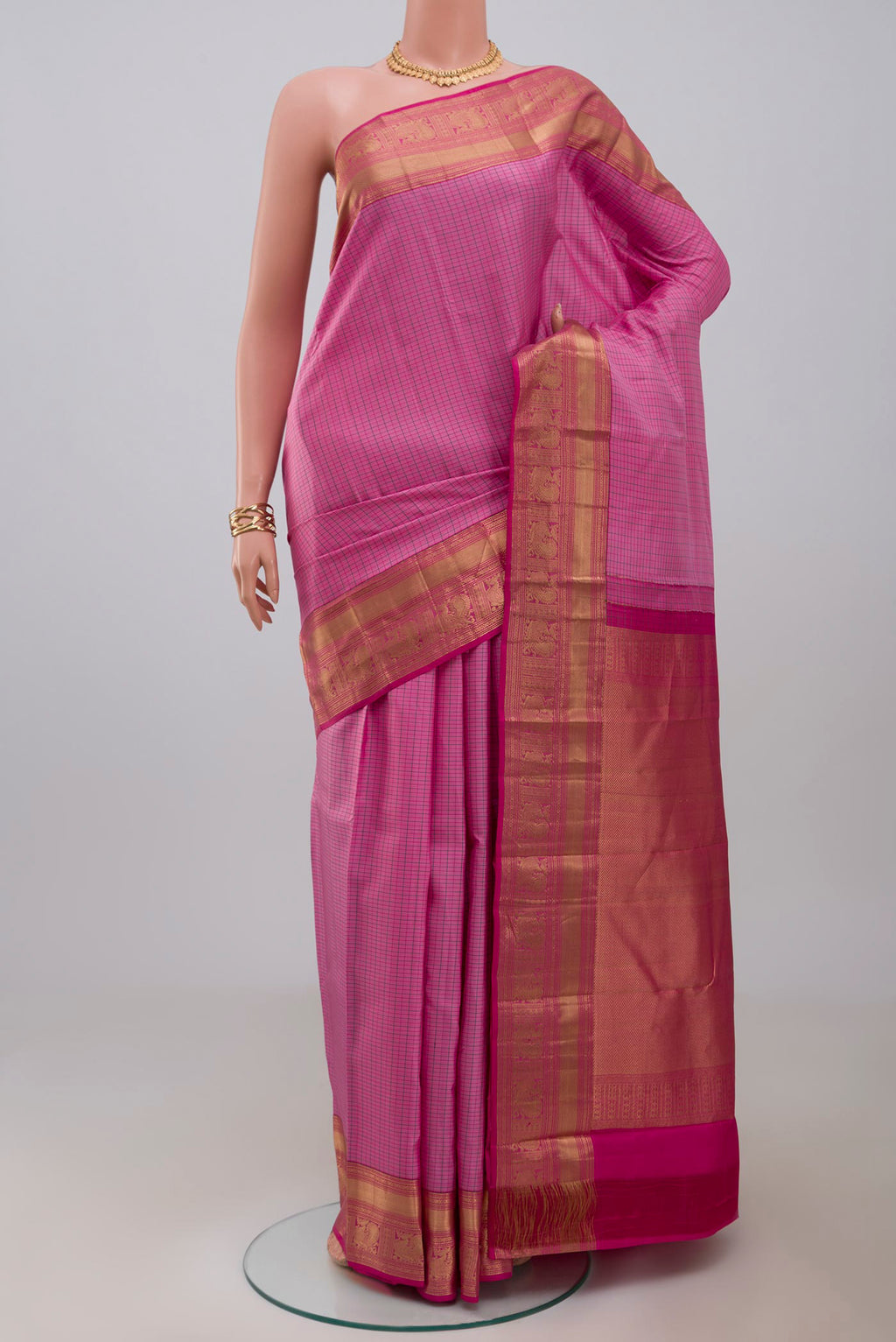 Pink Kanchipuram Saree with Checked design on the body and Zari Border.  displayed on a mannequin