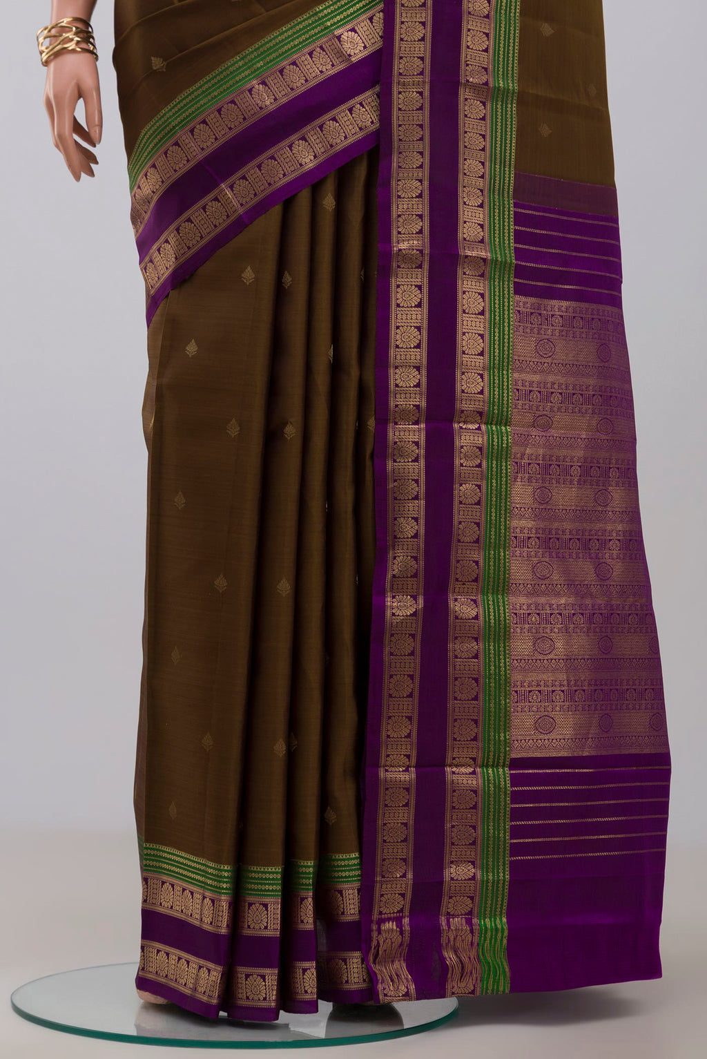 Pleats and pallu of Mehandi Green Kanchipuram Silk Saree with Zari Butta on the body and Zari Border. 
