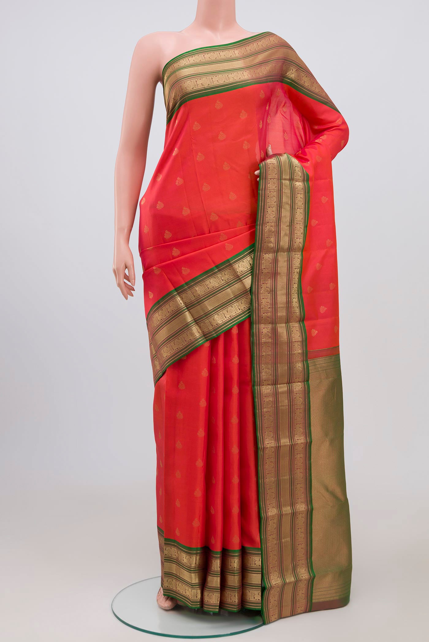 Orange Kanchipuram Saree with Zari Butta on the body and Zari Border.  displayed on a mannequin