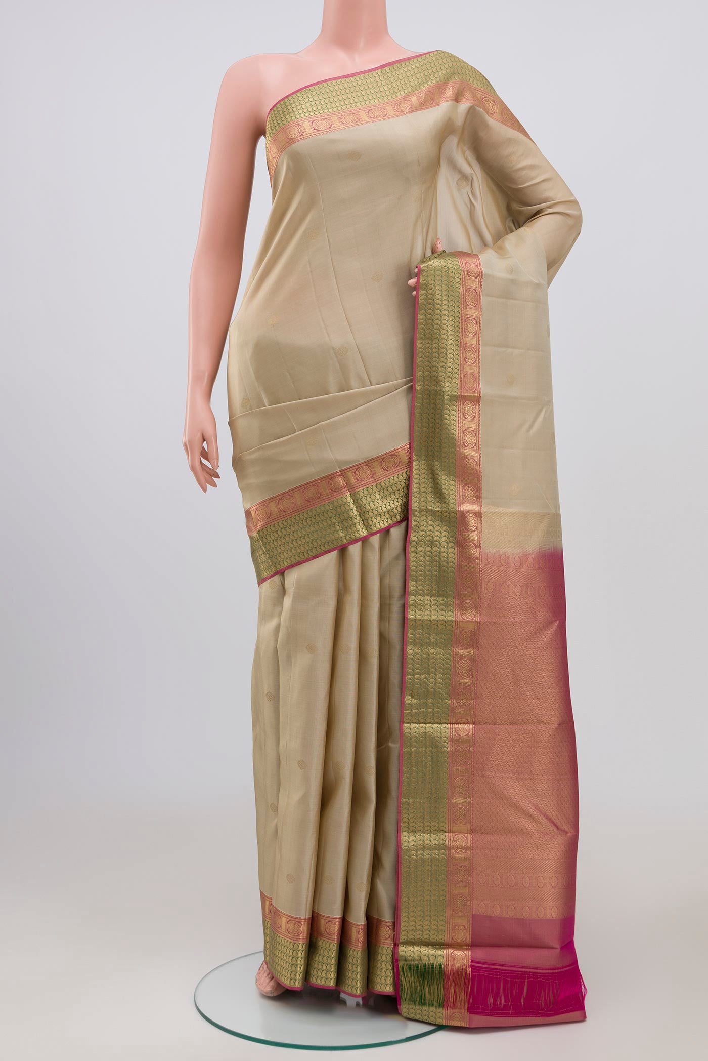 Cream Kanchipuram Saree with Zari Butta on the body and Zari Border.  displayed on a mannequin