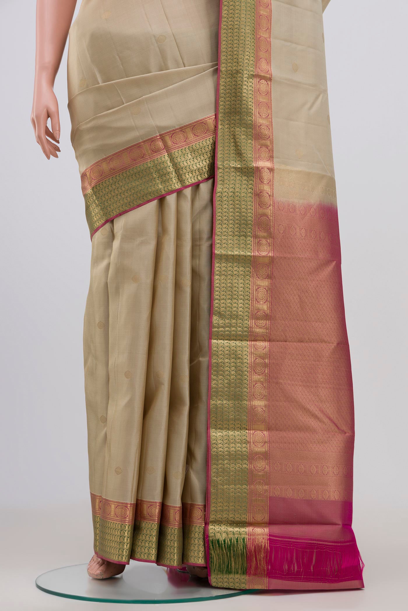Pleats and pallu of Cream Kanchipuram Saree with Zari Butta on the body and Zari Border. 