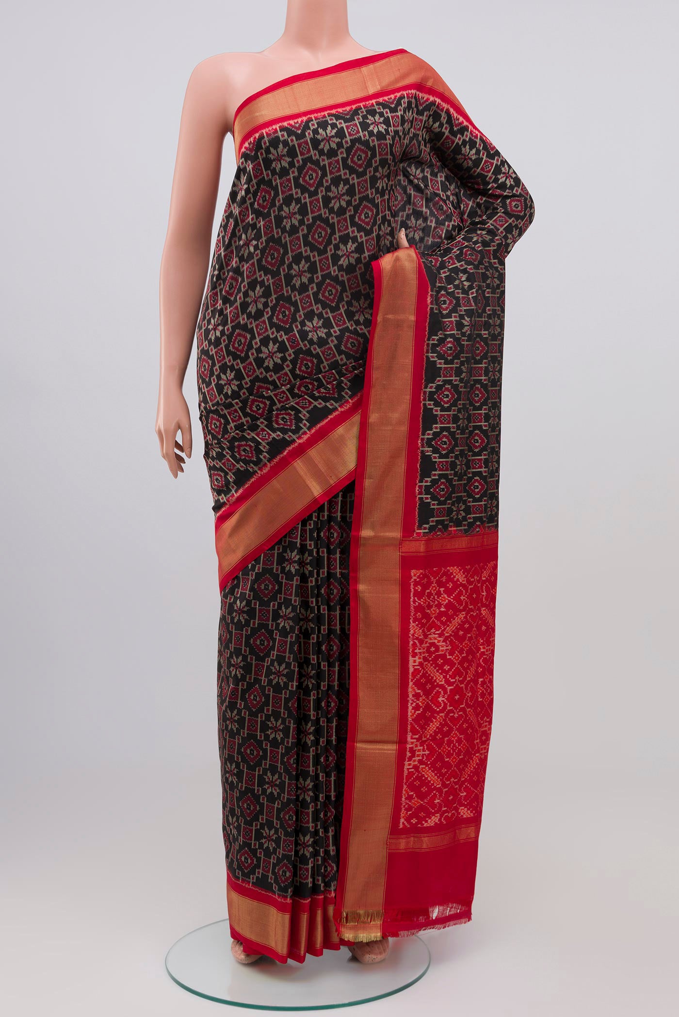 Black Pochampally Silk Saree with Ikat design on the body and Zari Border.  displayed on a mannequin