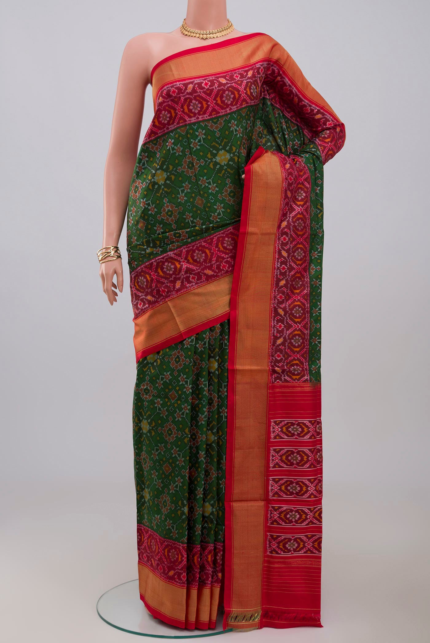 Green Pochampally Silk Saree with Ikat design on the body and Zari Border.  displayed on a mannequin