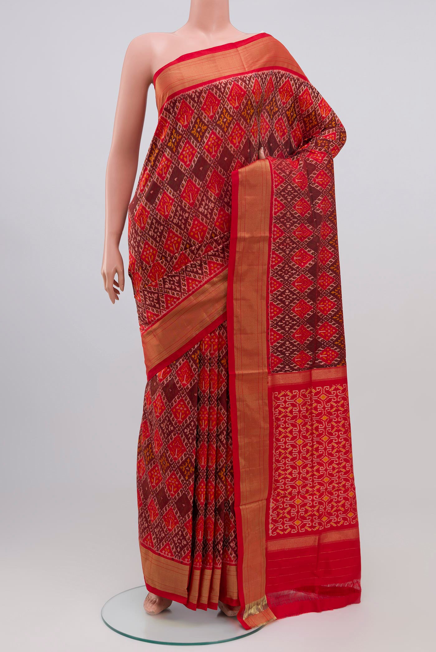 Orange Pochampally Silk Saree with Ikat design on the body and Zari Border.  displayed on a mannequin