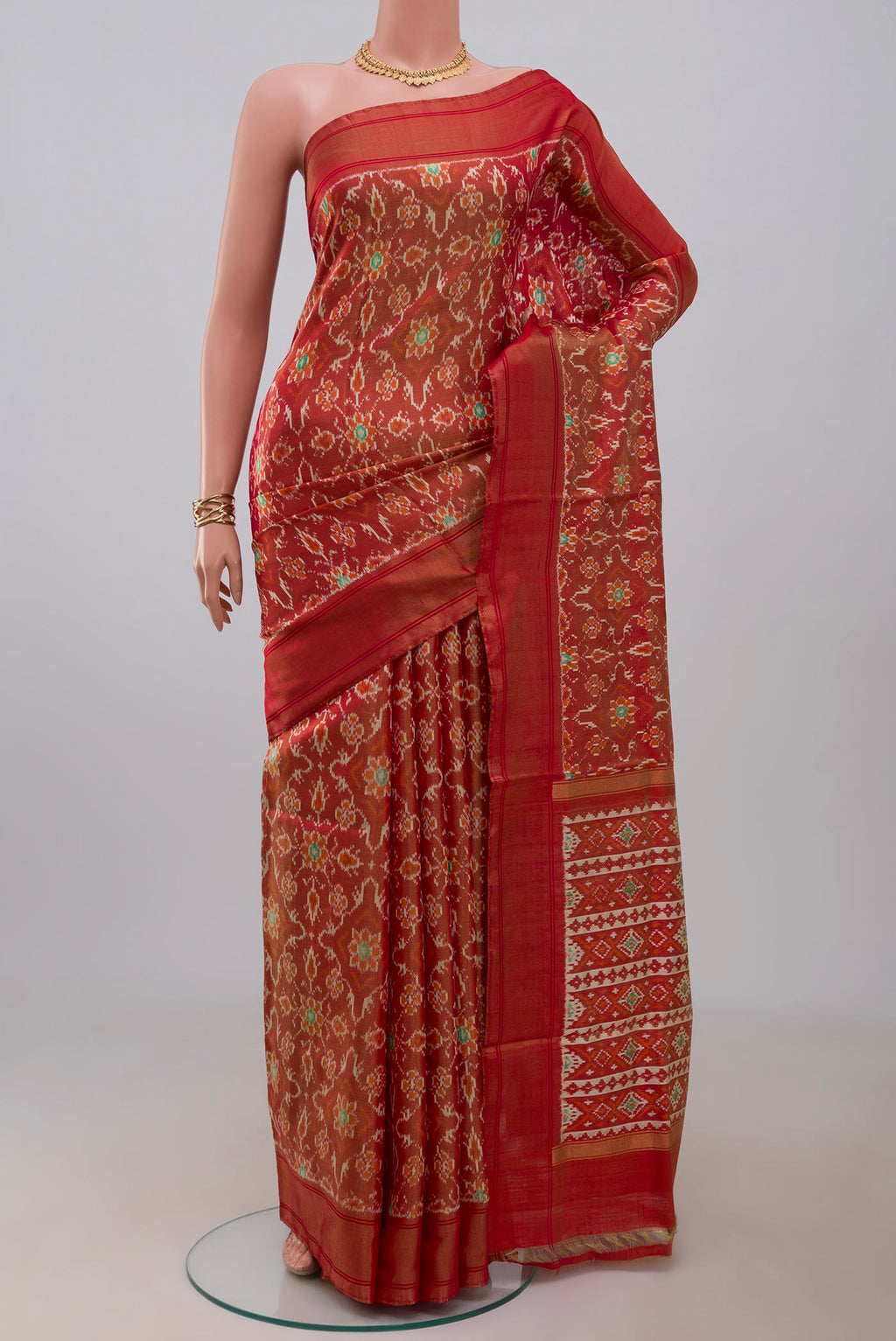 Rust Pochampally Saree with Ikat design on the body and Zari Border.  displayed on a mannequin