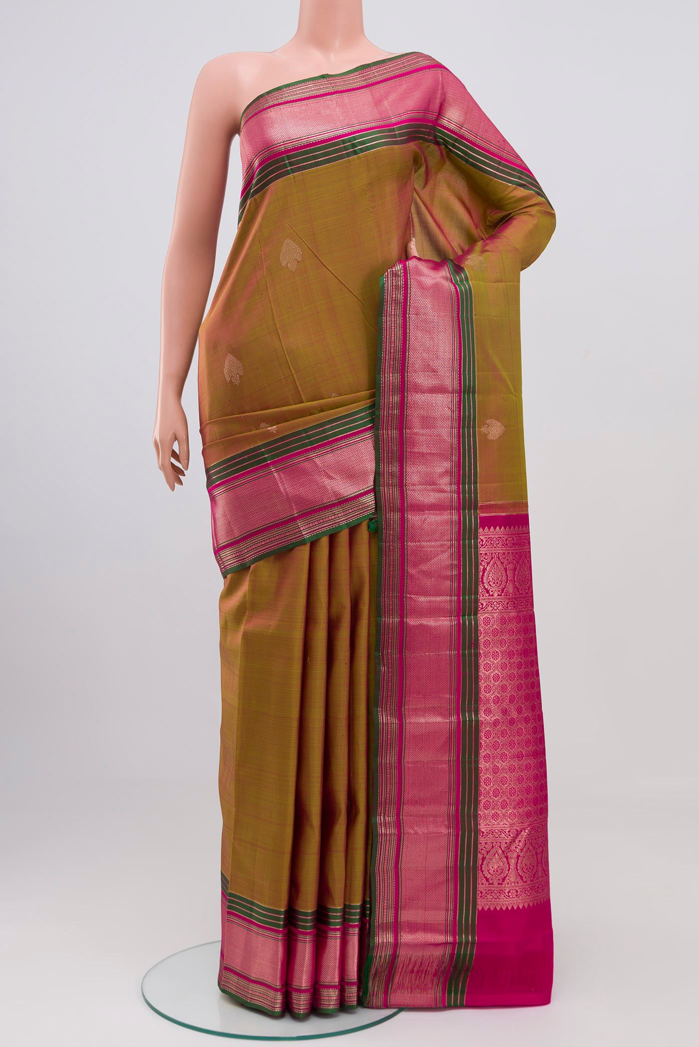 Green Kanjivaram Saree with Zari Butta on the body and Zari Border.  displayed on a mannequin