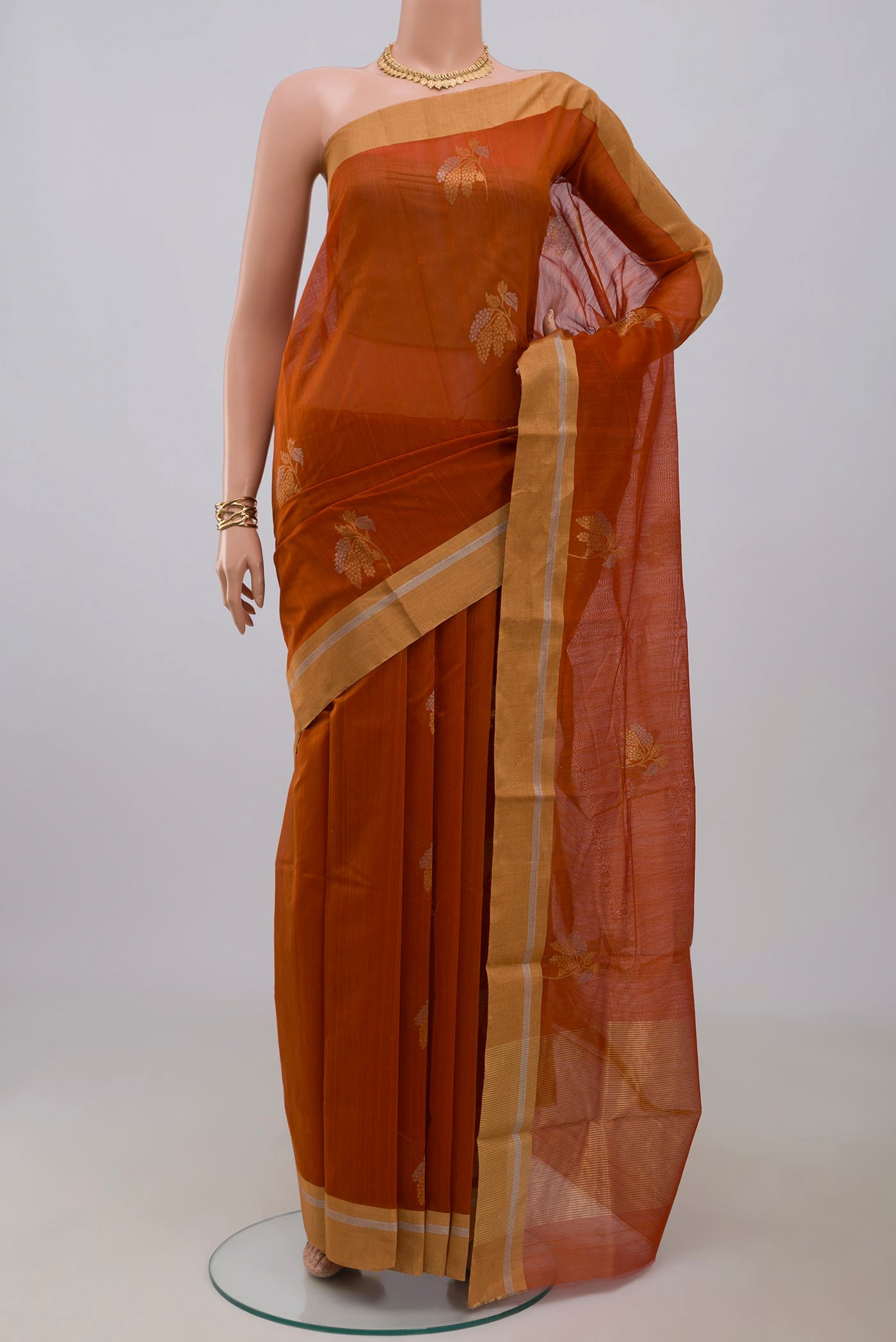 Rust Chanderi Silk Cotton Saree with Zari Butta on the body and Zari Border.  displayed on a mannequin
