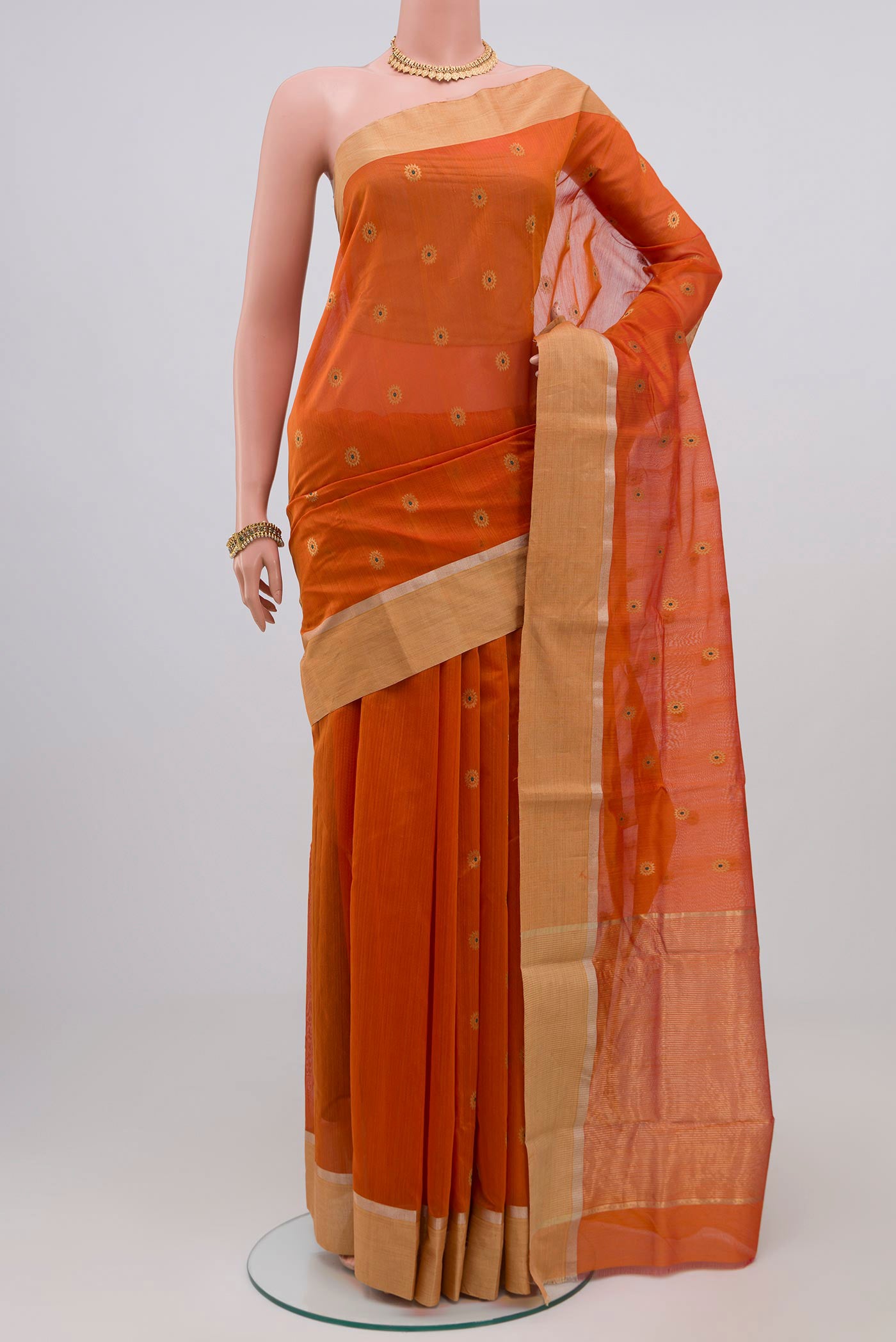 Brick Orange Chanderi Silk Cotton Saree with Zari Butta on the body and Zari Border.  displayed on a mannequin