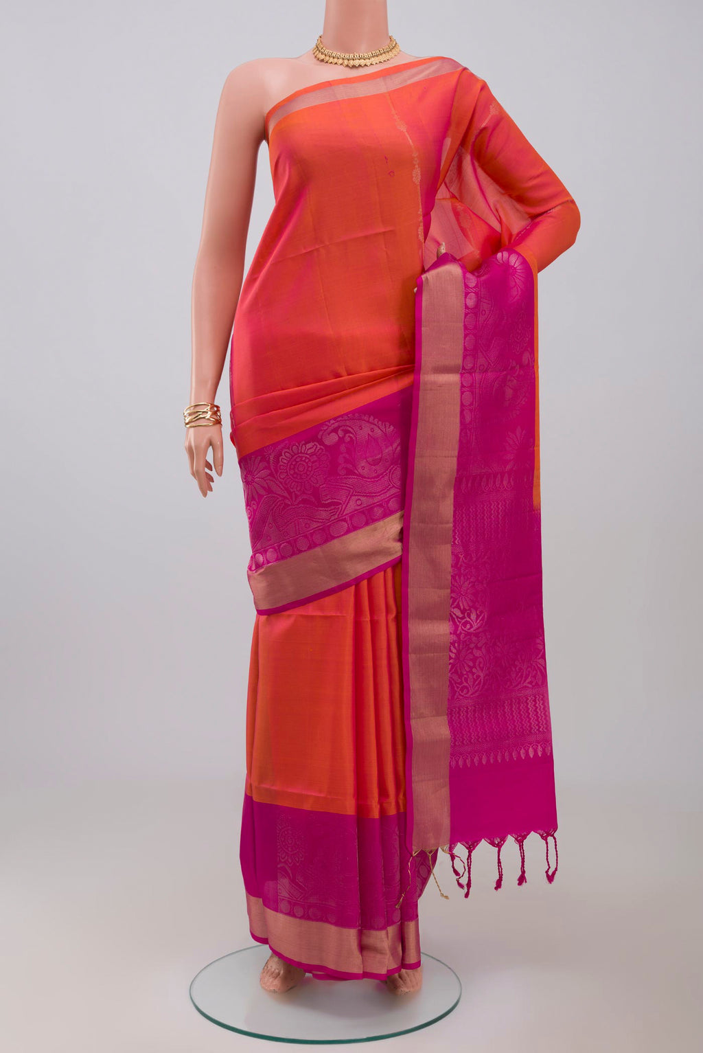 Orange Soft Silk Saree with Fancy on the body and Fancy Border.  displayed on a mannequin