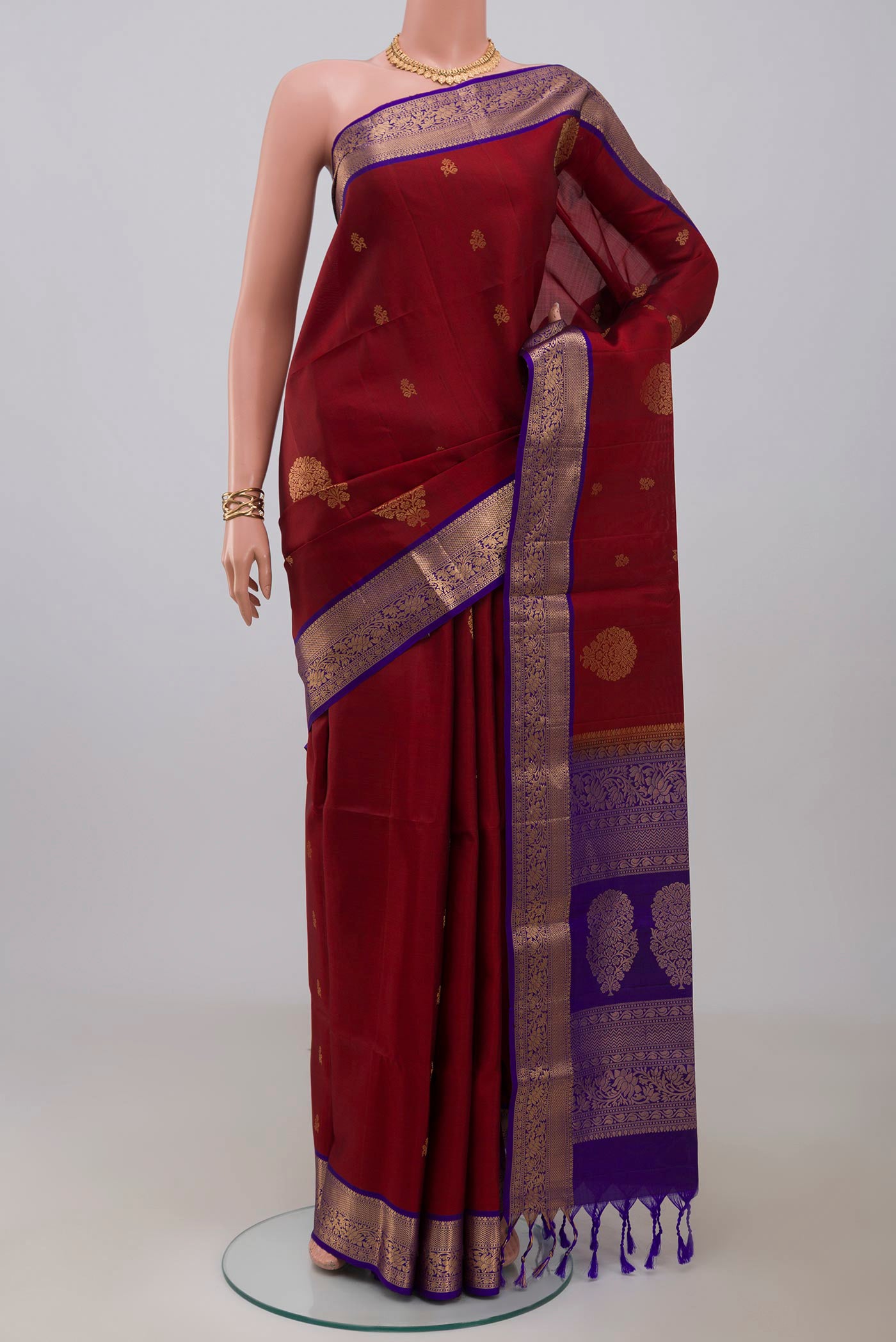 Maroon Soft Silk Saree with Zari Butta on the body and Zari Border.  displayed on a mannequin