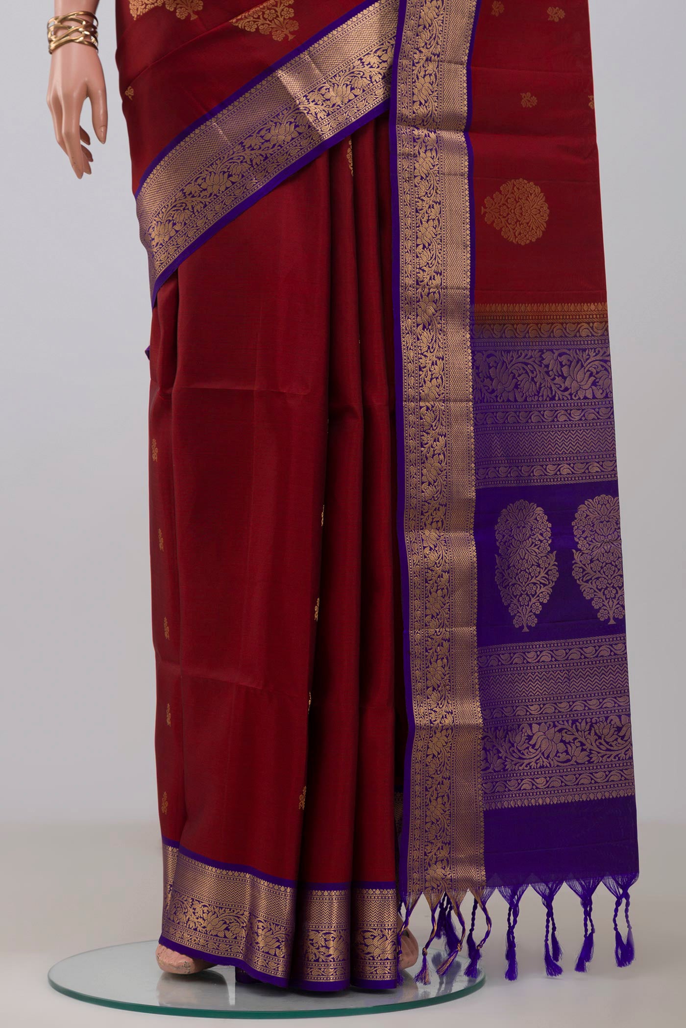 Pleats and pallu of Maroon Soft Silk Saree with Zari Butta on the body and Zari Border. 
