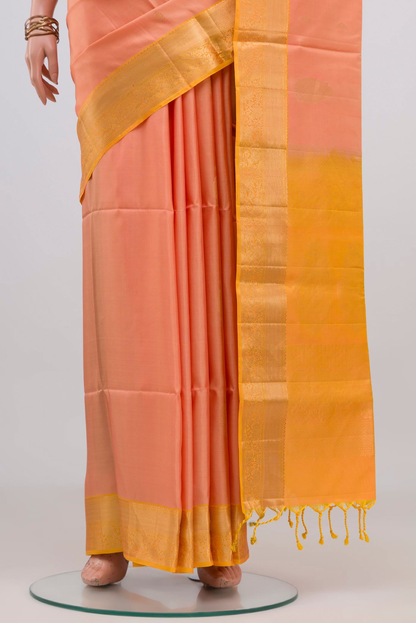 Pleats and pallu of Peach Soft Silk Saree with Zari Butta on the body and Zari Border. 