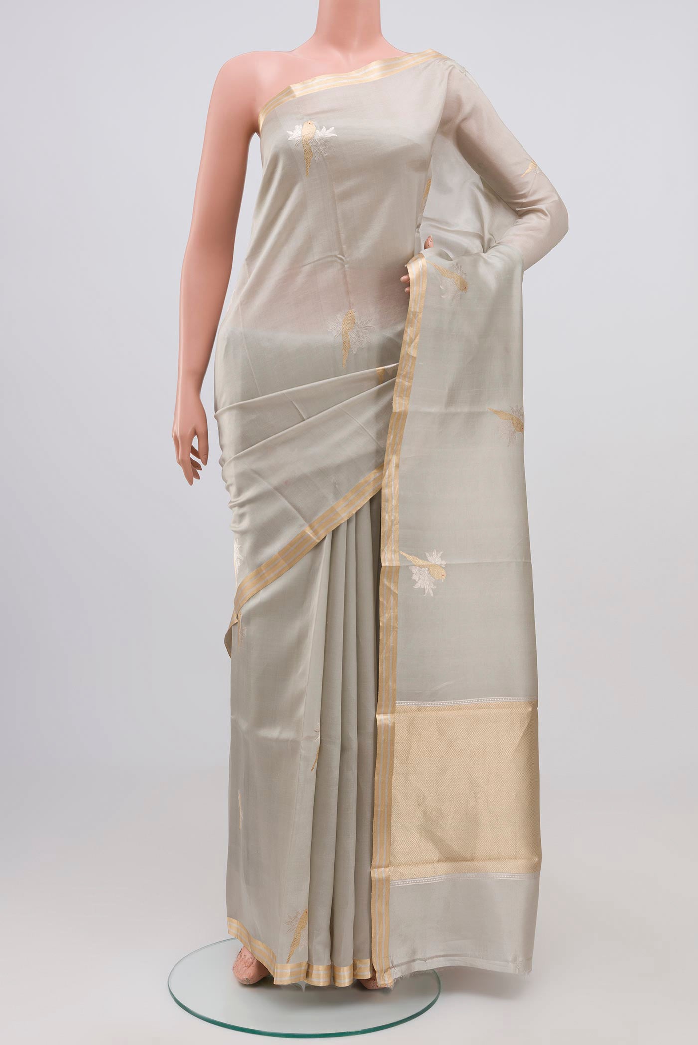 Grey Banarasi Katan Silk Saree with Zari Butta on the body and Zari Border.  displayed on a mannequin