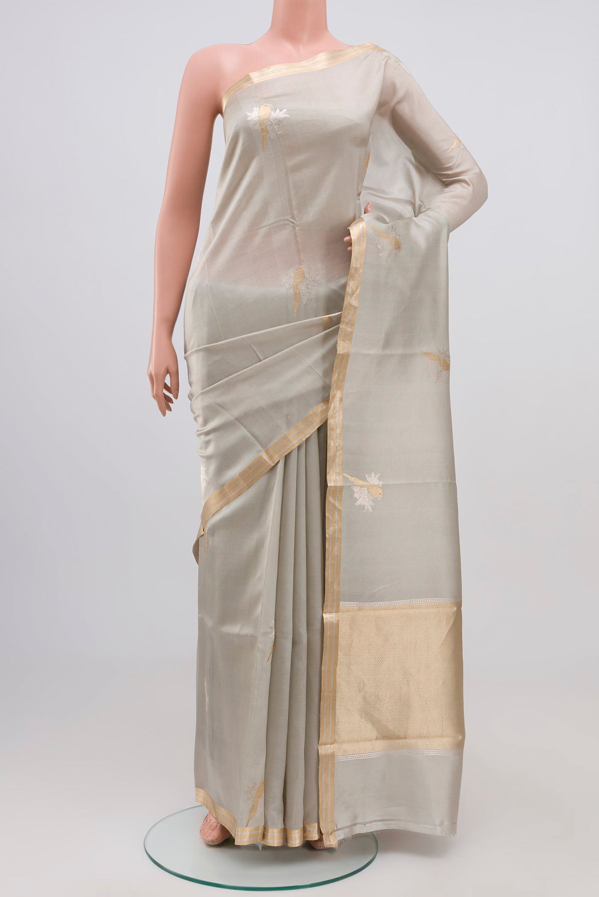 Grey Banarasi Katan Silk Saree with Zari Butta on the body and Zari Border.  displayed on a mannequin