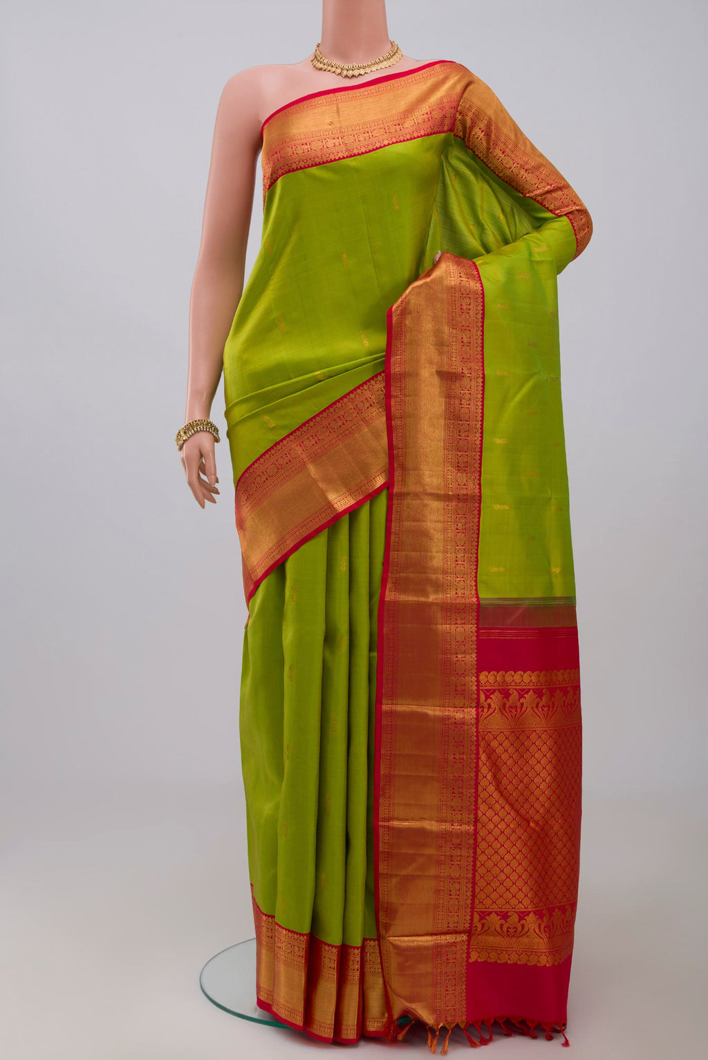 Green Kanjivaram Saree with Zari Butta on the body and Zari Border.  displayed on a mannequin