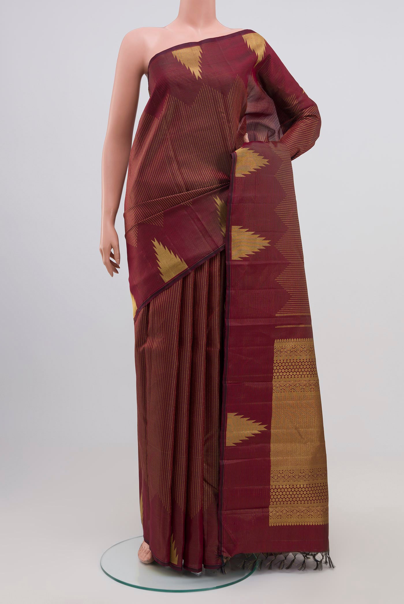 Maroon Kanjivaram Silk Saree with Zari Brocade on the body and Temple Border.  displayed on a mannequin