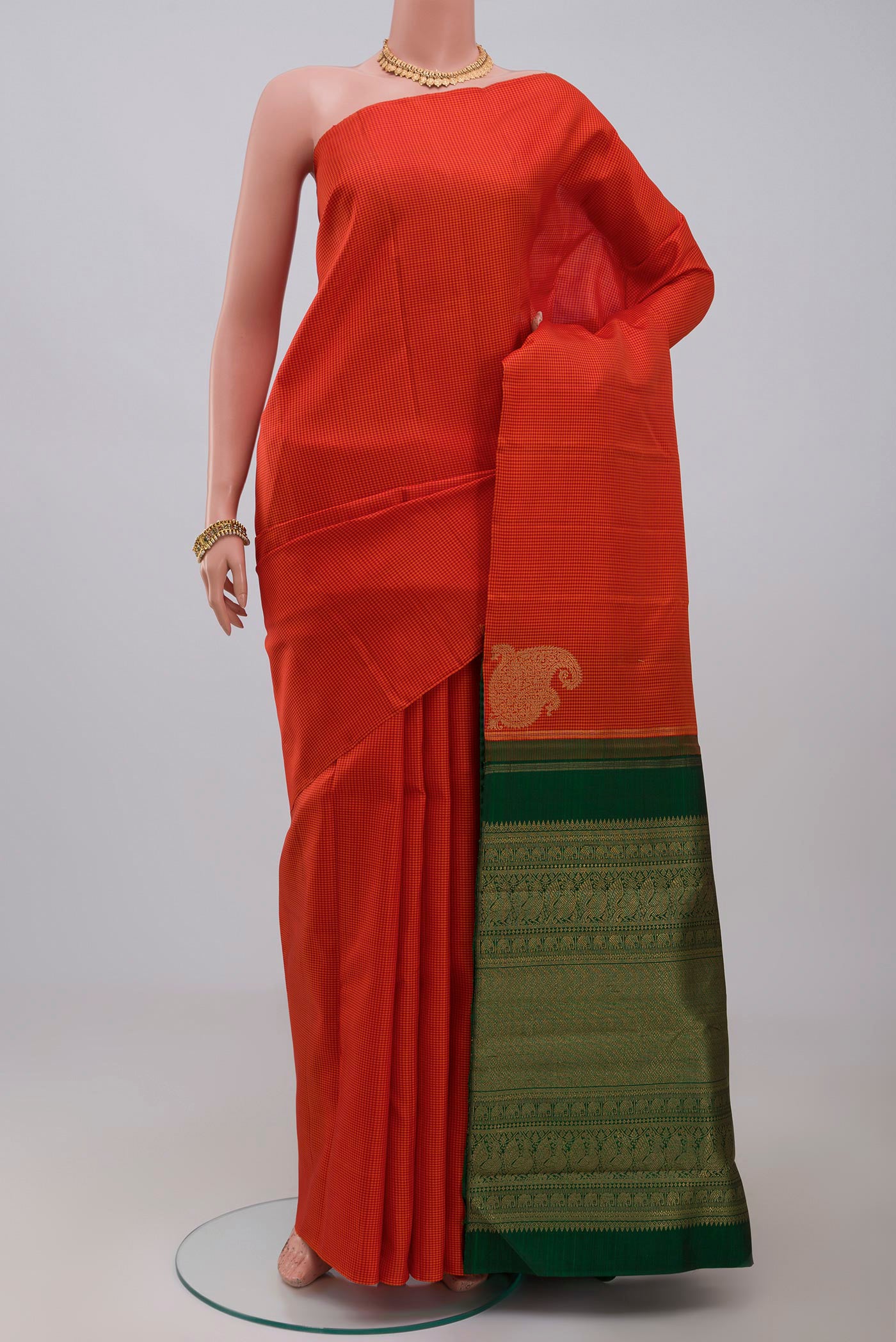 Pure Silk Pure Zari Orange Kanchipuram Saree with Checked design on the body and Without Border.  displayed on a mannequin
