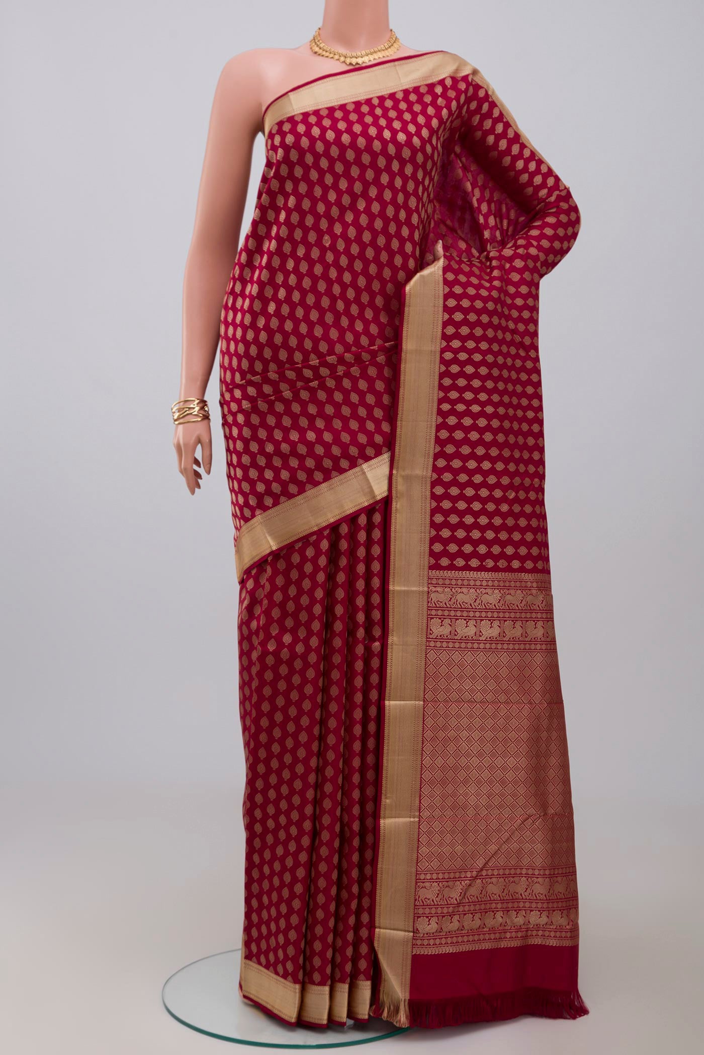 Maroon Kanchipuram Silk Saree with Thread Butta on the body and Thread Border.  displayed on a mannequin