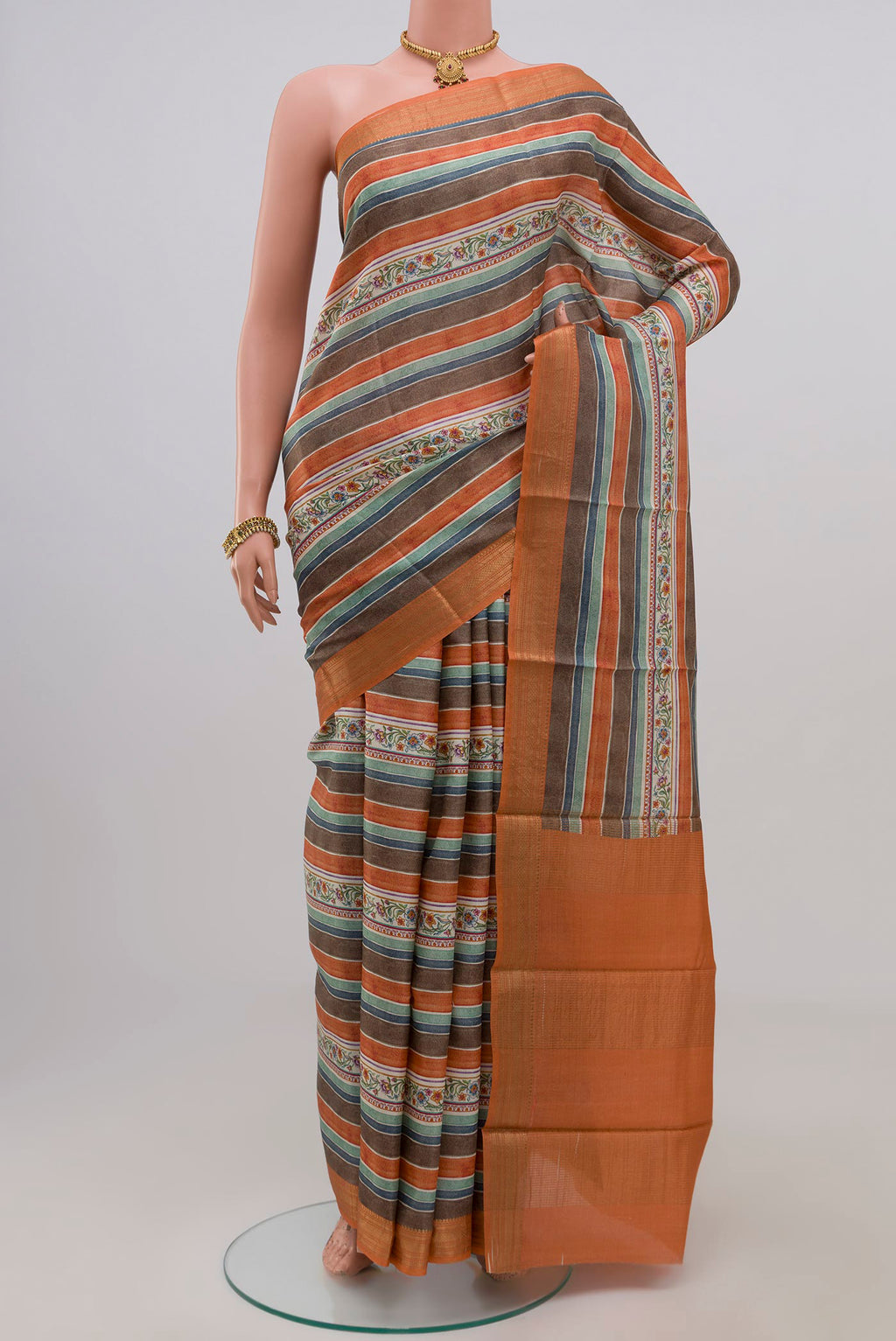Orange Tussar Silk Saree with Fancy on the body and Zari Border.  displayed on a mannequin