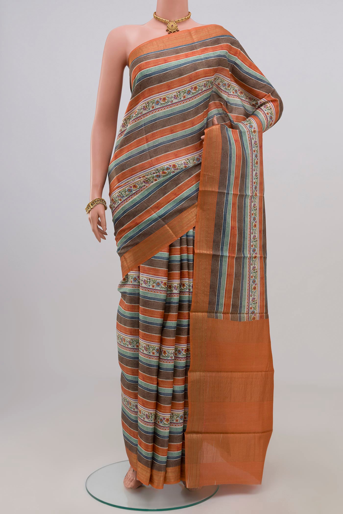 Orange Tussar Silk Saree with Fancy on the body and Zari Border.  displayed on a mannequin