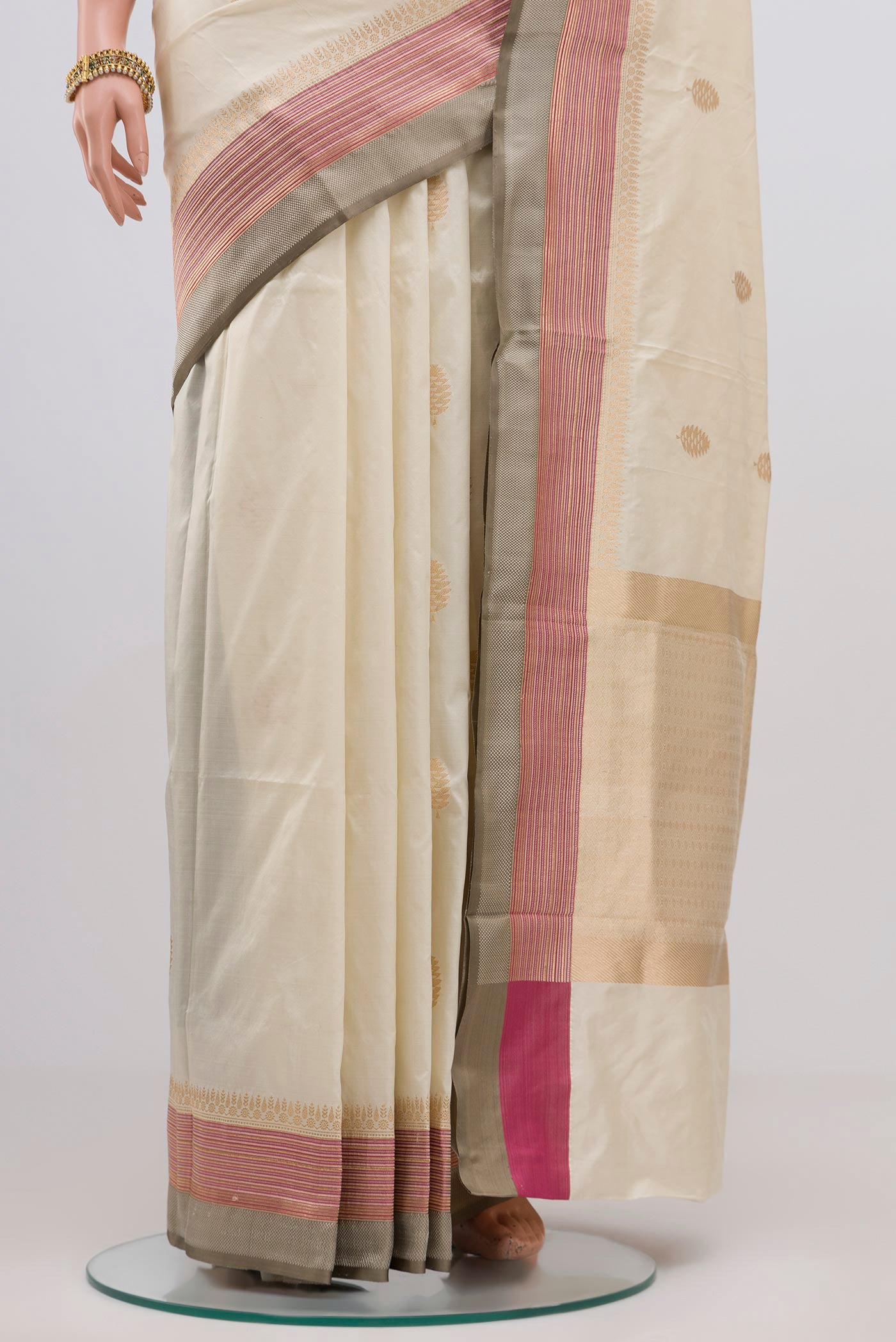 Pleats and pallu of Cream Banarasi Katan Silk Saree with Zari Butta on the body and Thin Zari Line. 