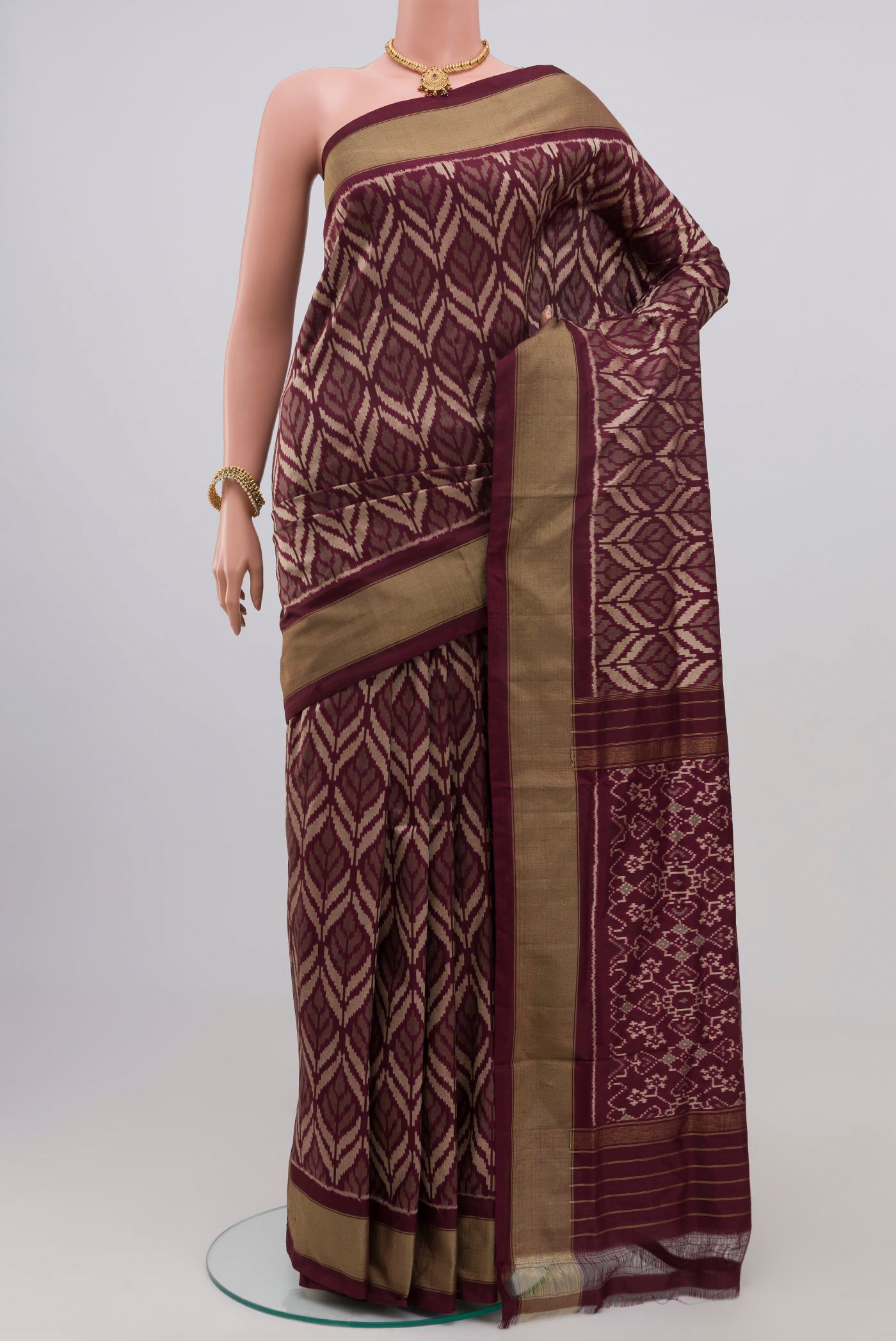 Brown Pochampally Silk Saree with Ikat Print on the body and Zari Border.  displayed on a mannequin