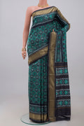 Green Pochampally Silk Saree with Ikat design on the body and Zari Border.  displayed on a mannequin