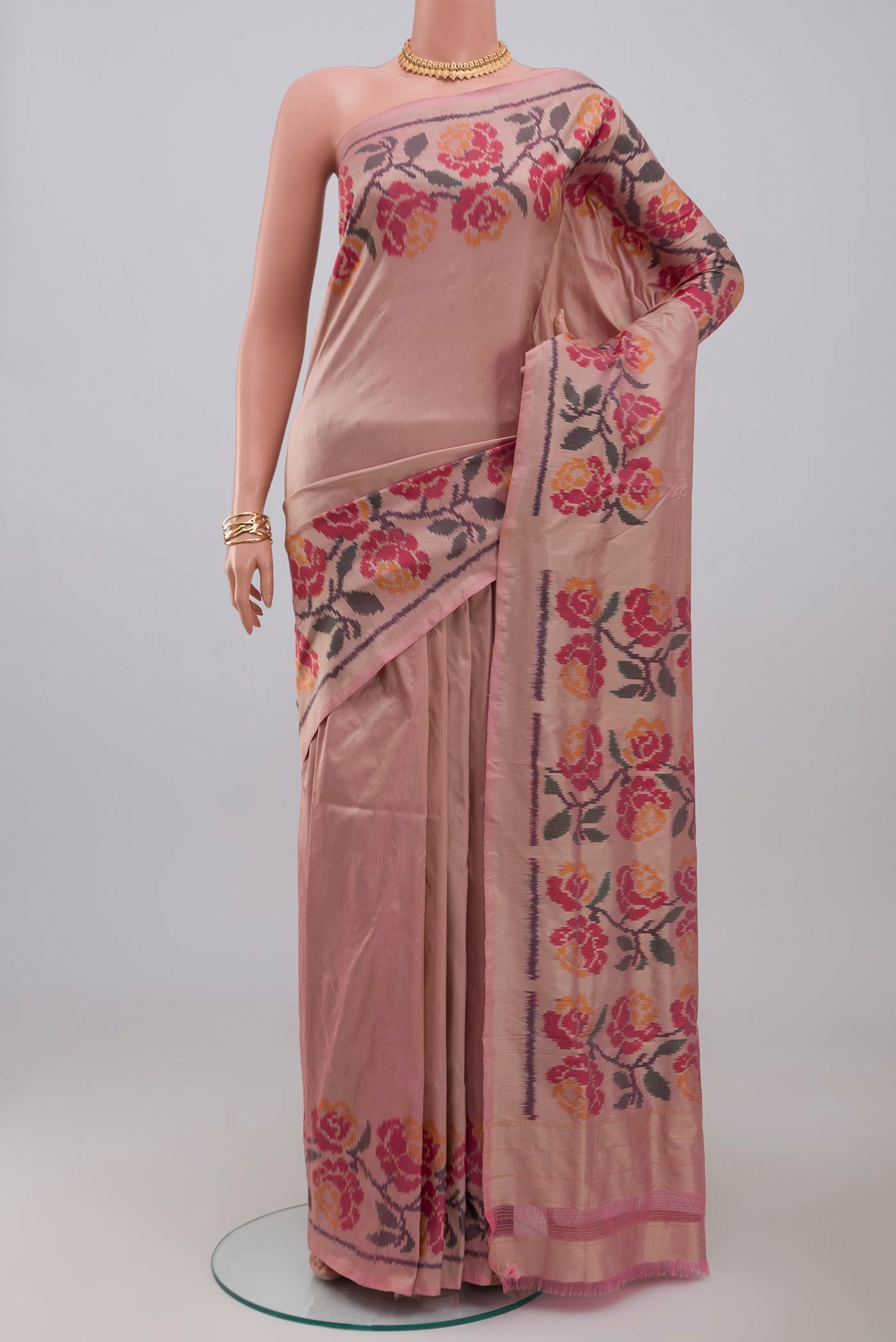 Peach Pochampally Silk Saree with Ikat design on the body and Ikat Border.  displayed on a mannequin