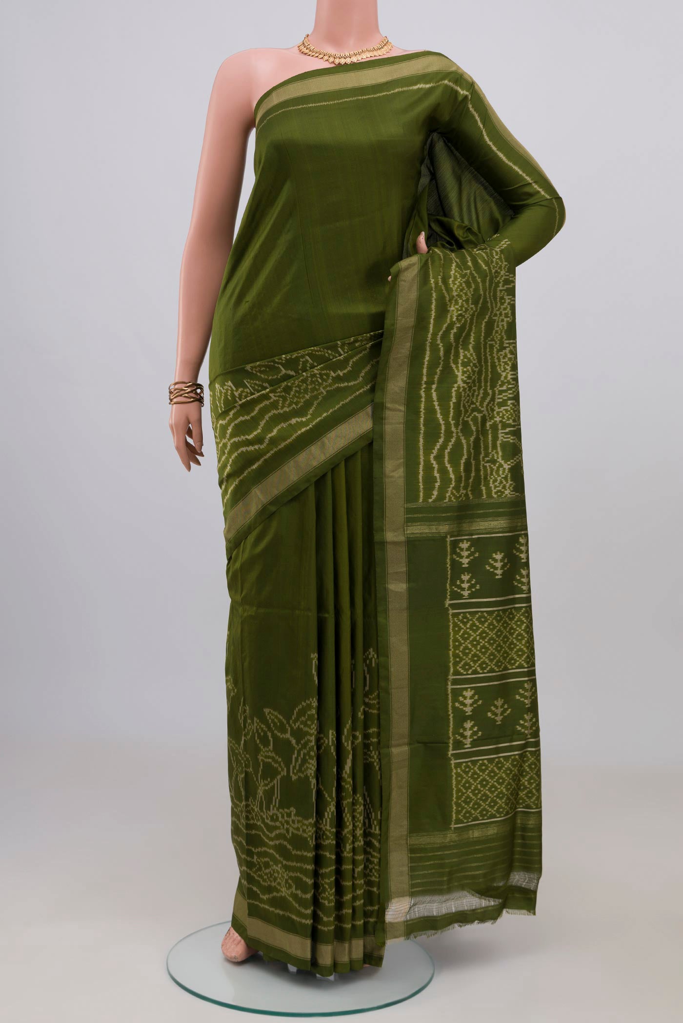 Mehandi Green Pochampally Silk Saree with Ikat design on the body and Thin Zari Line.  displayed on a mannequin